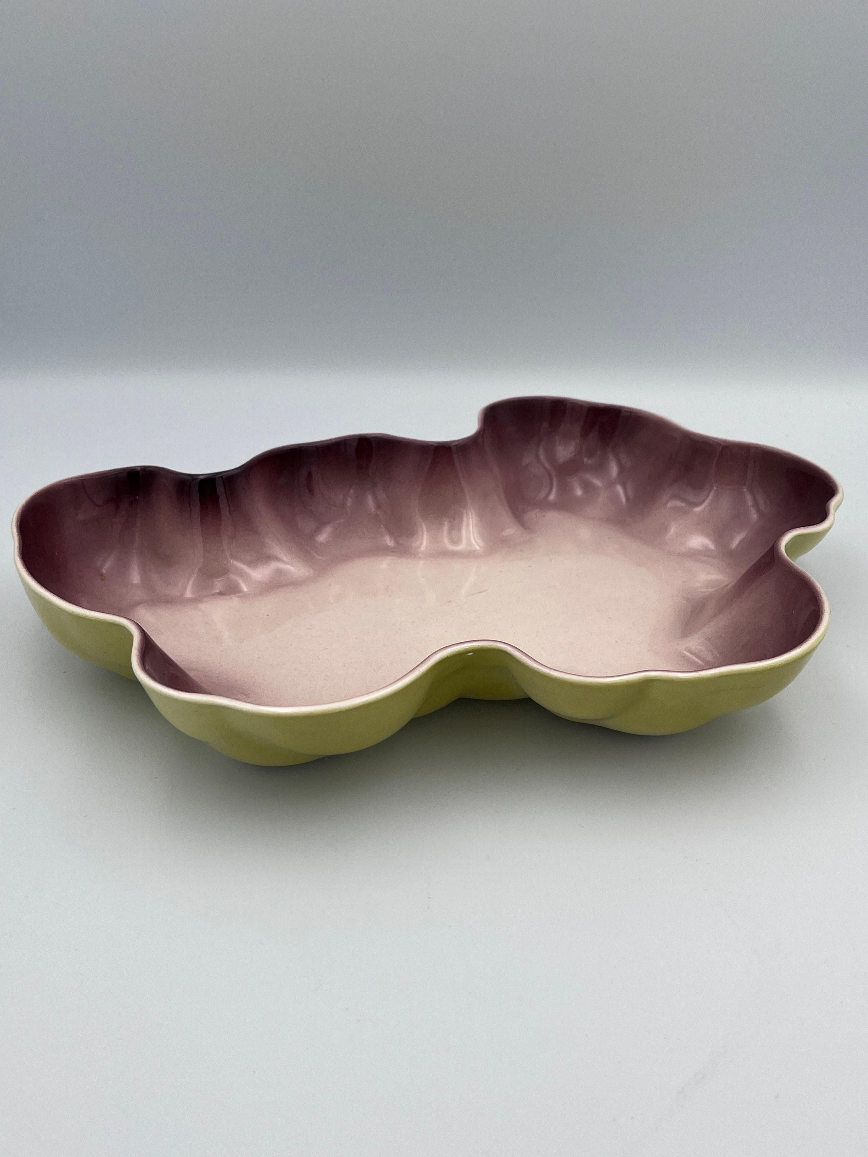 This rare 1952 Flamingo Bowl by Los Angeles Potteries is a striking example of mid-century California ceramics. Finished in a vibrant yellow glaze, the bowl features an irregular, amorphous shape reminiscent of organic modernist design. The interior