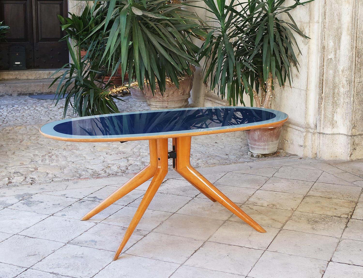 Exceptional blue and pale blue glass oval dining table designed and created by the renowned Italian designer, Ico Parisi in the 1950s. The light coloured wooden iconic Ico Parisi base and legs support this wonderful glass table top. The central