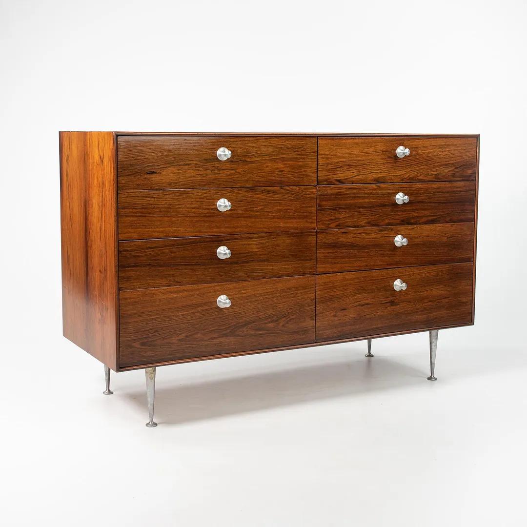 Listed for sale is a circa 1953 production Model 5221 Thin Edge dresser / cabinet, designed by George Nelson, produced by Herman Miller. Notably, this example was specified in the most sought after rosewood variant with classic aluminum Thin Edge