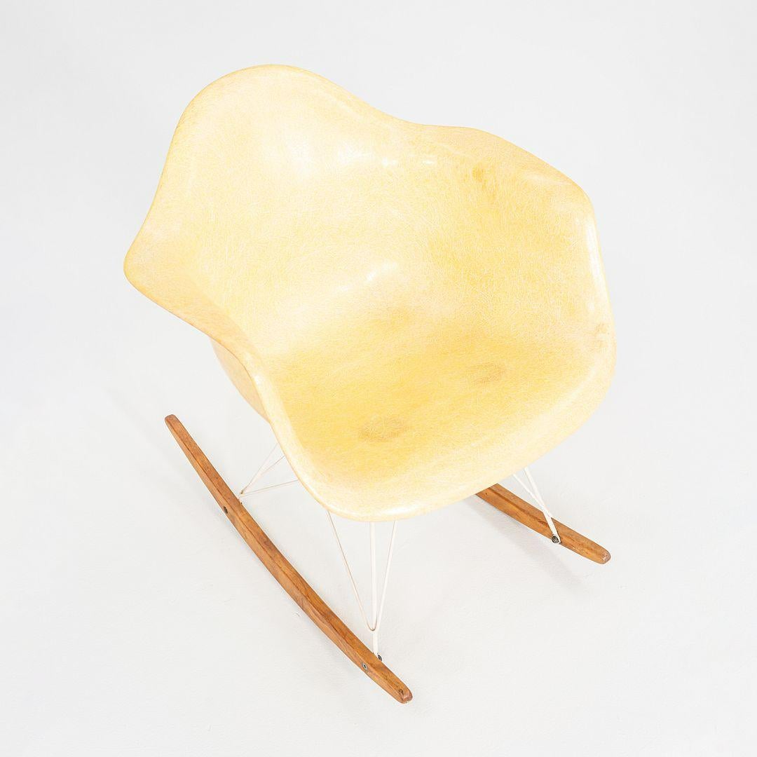 Questa è una sedia a dondolo RAR, progettata da Charles e Ray Eames nel 1950. Questo particolare esemplare risale al 1953 circa. Il pezzo è composto da una seduta e uno schienale a guscio in fibra di vetro gialla e da gambe in acciaio verniciato