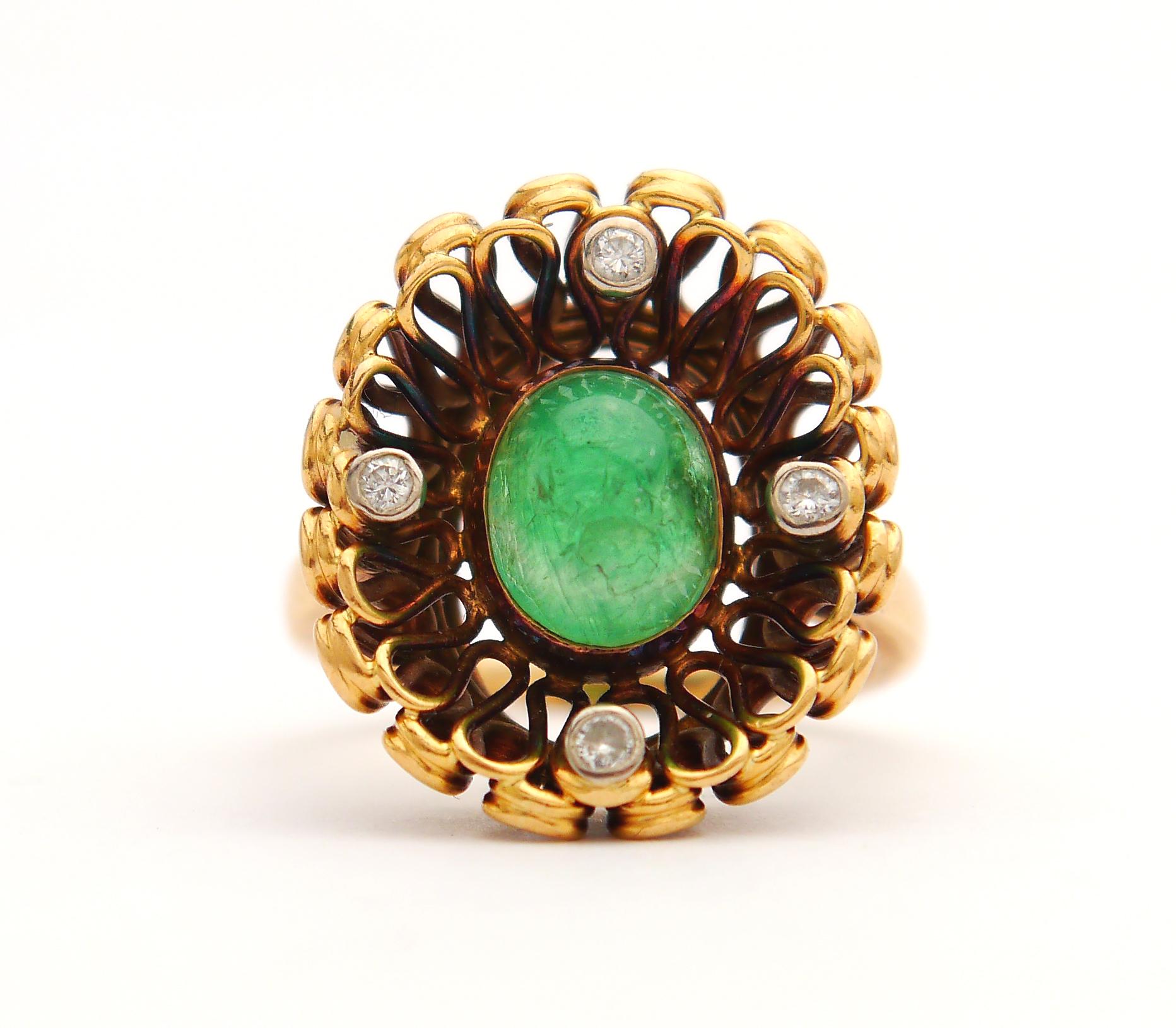 A ring with medium green cabochon cut natural Emerald  bezel set in wired floret in solid 18K Gold accented with four diamond cut Diamonds arranged in cross formation.

Crown is 20 mm x 17 mm. The facial side of the crown was artificially patinated
