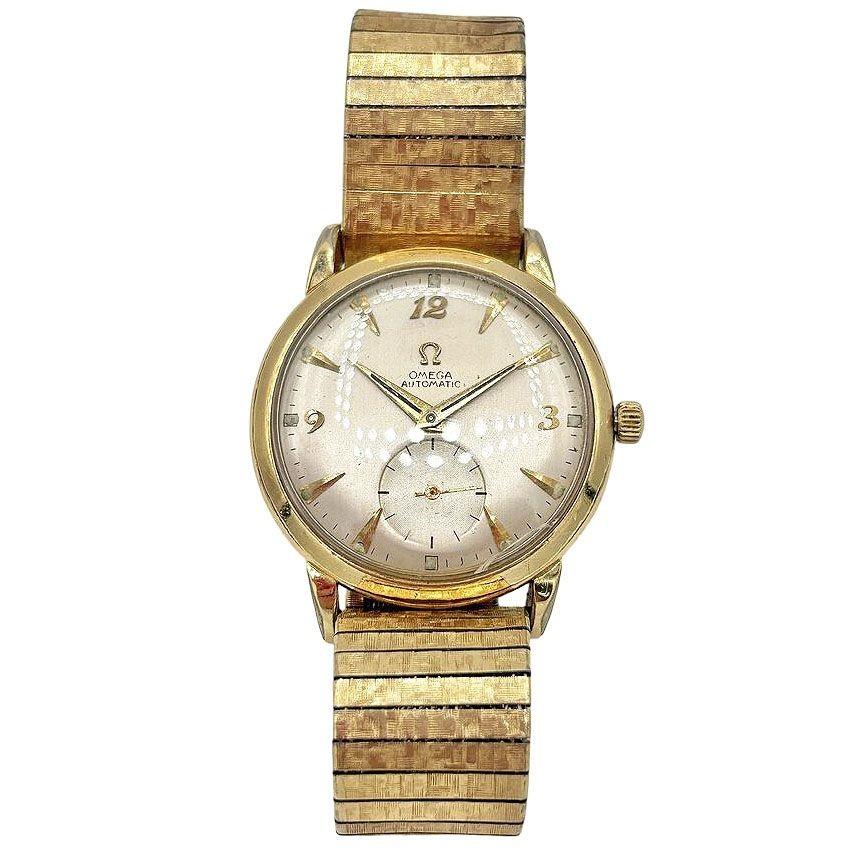 Mid-century era 1954 mens Omega automatic watch features a 14k gold-filled case and automatic bumper movement, known for its smooth winding action. The watch is paired with a Speidel USA 10K gold-filled top caps and a stainless steel mesh band,
