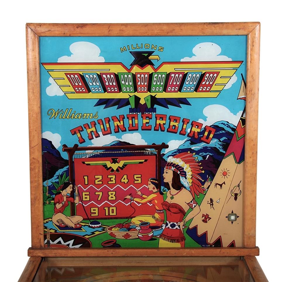 An American mid-1950s Williams 'Thunderbird' pinball machine.
The backglass and playfield are in very good condition; the original graphics of the case are present but fairly distressed, as shown.
Functional and playable.