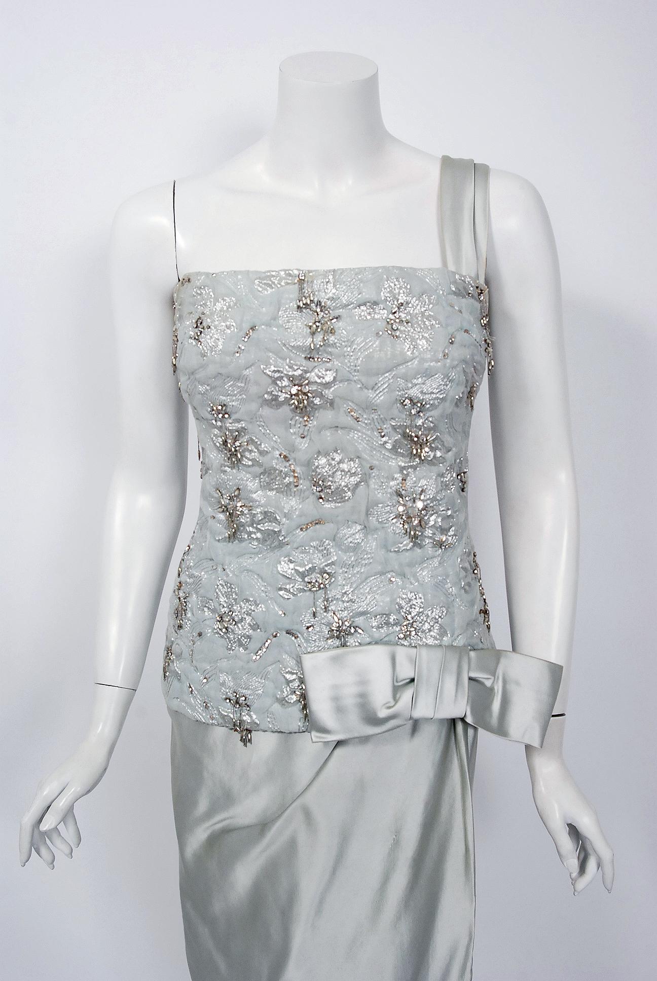 Beautiful ice-blue beaded metallic silk and satin gown by the famous House of Maggy Rouff. This gorgeous garment dates back to their 1955 haute couture collection. Harmony and simplicity were cornerstones of Maggy Rouff's belief in elegance as a way