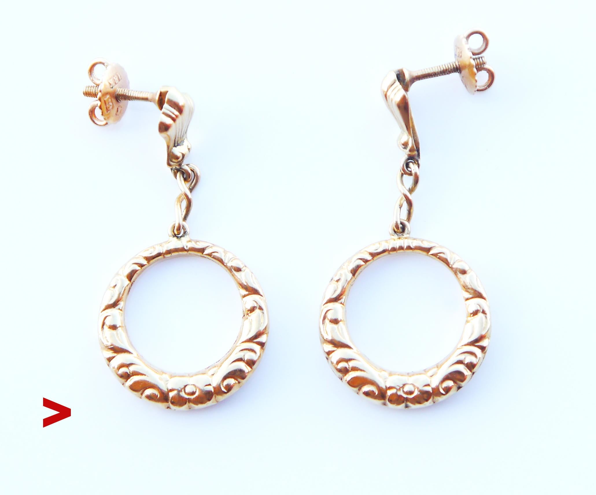 A pair of creole-shaped dangles in 18K Yellow Gold with cast floral ornaments on both sides chained to screwed hangers.
Rings look naturally voluminous being hollow inside. Both dangles are freely suspended and will mark any slightest movement of