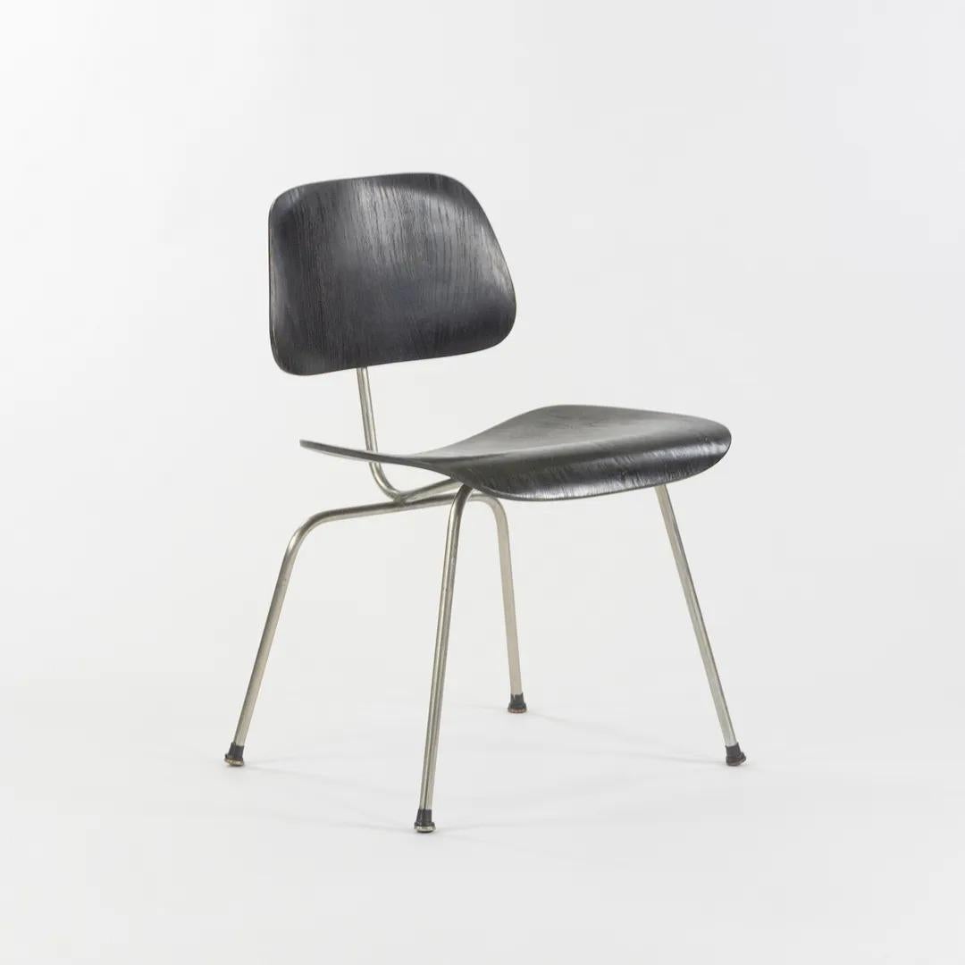 Listed for sale is a gorgeous and original circa 1955 Eames DCM dining chair with metal legs, produced by Herman Miller and designed by Ray and Charles Eames. This example has an black aniline dye finish, with chromed steel legs, and original boot