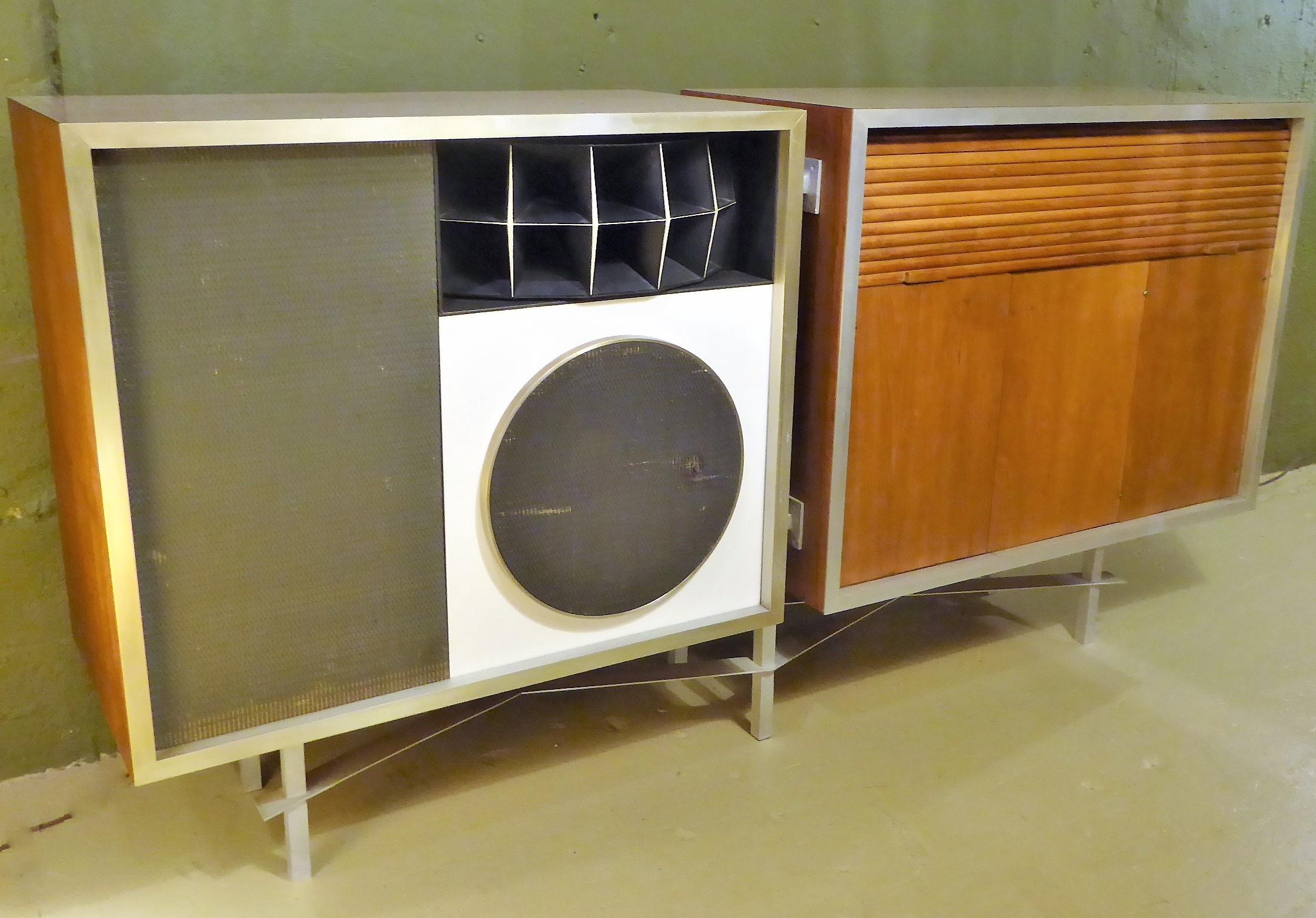 Offered here a custom designed Credenza featuring two cabinets. One with the rare Eames E-3 Stephens Tru-sonic Speaker System and the other cabinet with three doors and a tambour door retracting to show two small drawers and two serving trays. The