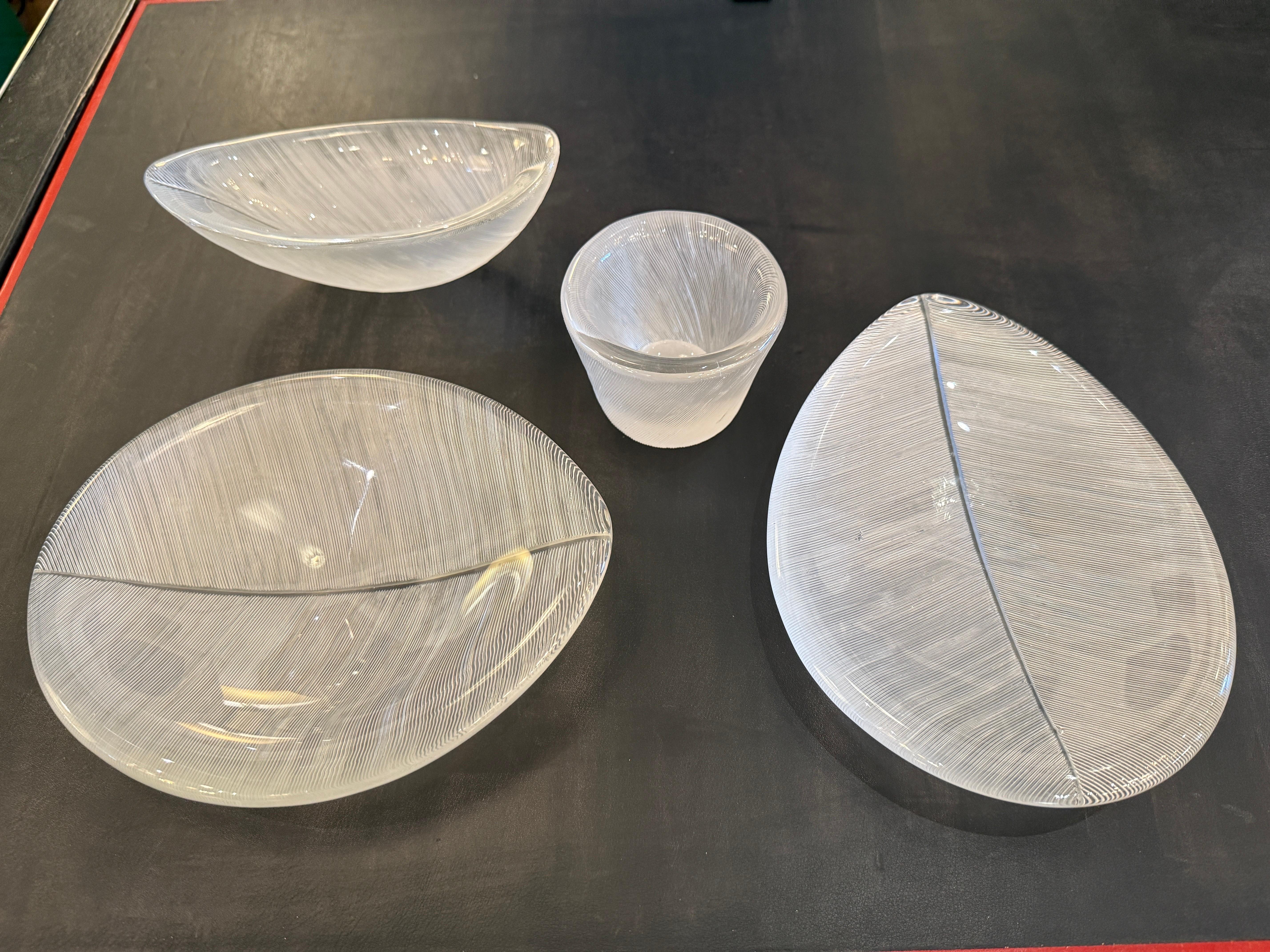 These etched SIGNED Tapio Wirkkala combed cut crystal grouping of bowls and cup are styled after large leaves which was one of Wirkkala's favorite motifs to use in his art glass.  One flat bowl is higher than the other slightly and all have texture