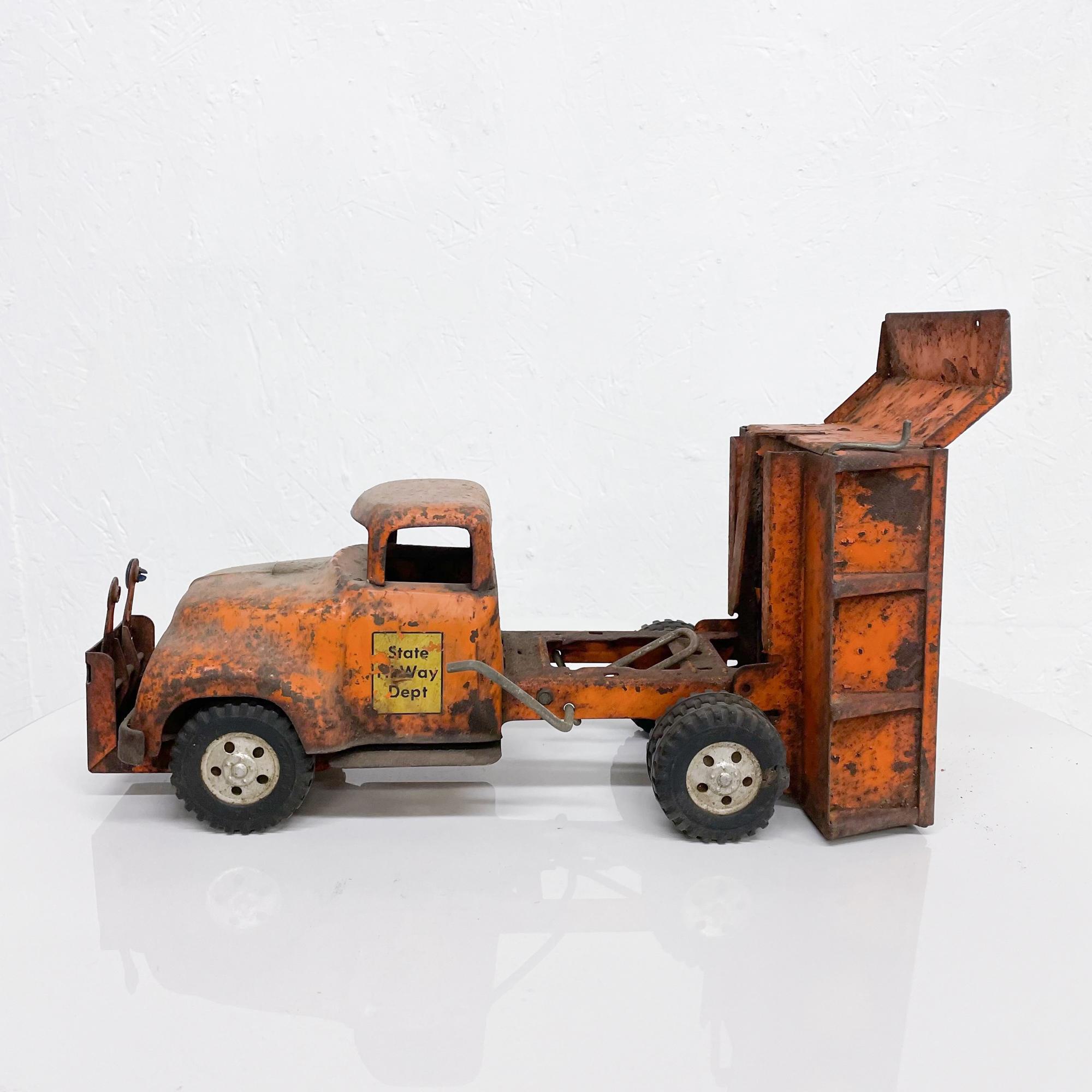 Vintage toy truck stamped state highway hi-way construction made by TONKA in 1956.
Big dump truck painted in orange. Rusted metal. Big rubber tires. Super cool.
Measures: 14 L x 6.25 W x 6.5 tall
Original unrestored vintage condition. Distressed