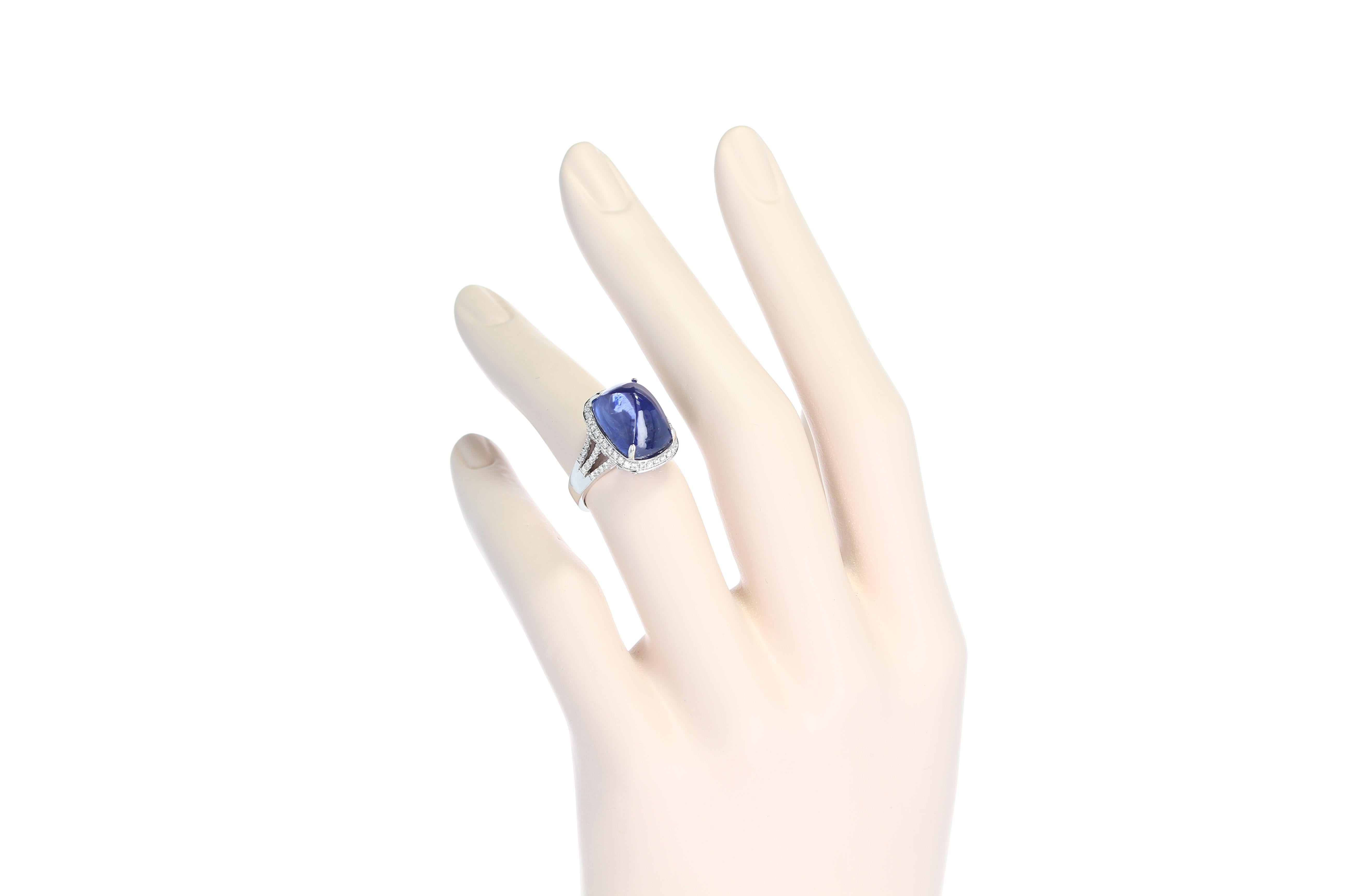A 19.57 carat cushion-shape sugarlaof blue sapphire cabochon with diamonds, set in 18kt white gold. The sapphire accompanies a gemological report from GIA & GRS stating the country of origin as Ceylon (Sri Lanka) with No Heat Enhancement. Ring Size: