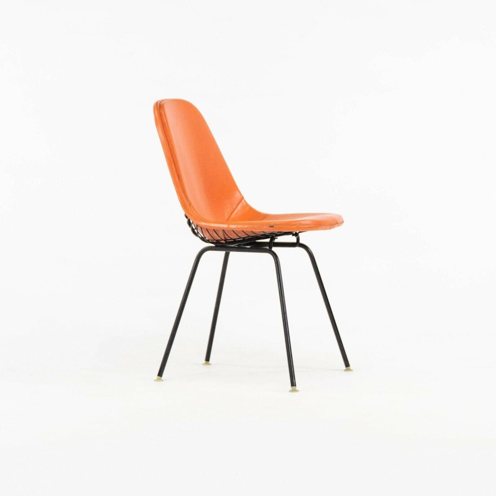 Listed for sale is a single circa 1957 production Eames DKX dining chair with wire upper and fully upholstered pad. The pad is original naugahyde in a red/orange color. The upholstery is overall in very nice shape, showing some wear from use as
