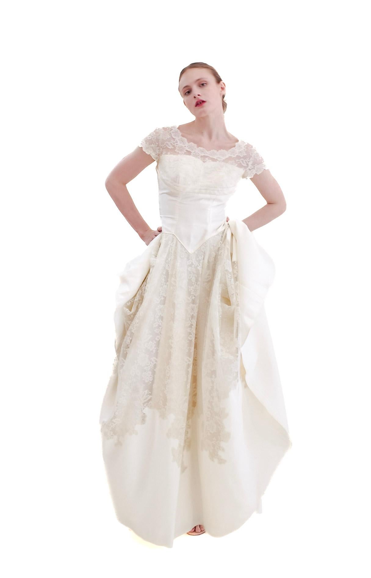 Elegantly embrace the timeless charm of the 1950s with our 1957 Vintage White Silk & Lace Wedding Dress. This princess style dress exudes a classic beauty that will make you feel like a true princess on your special day. Crafted with exquisite silk