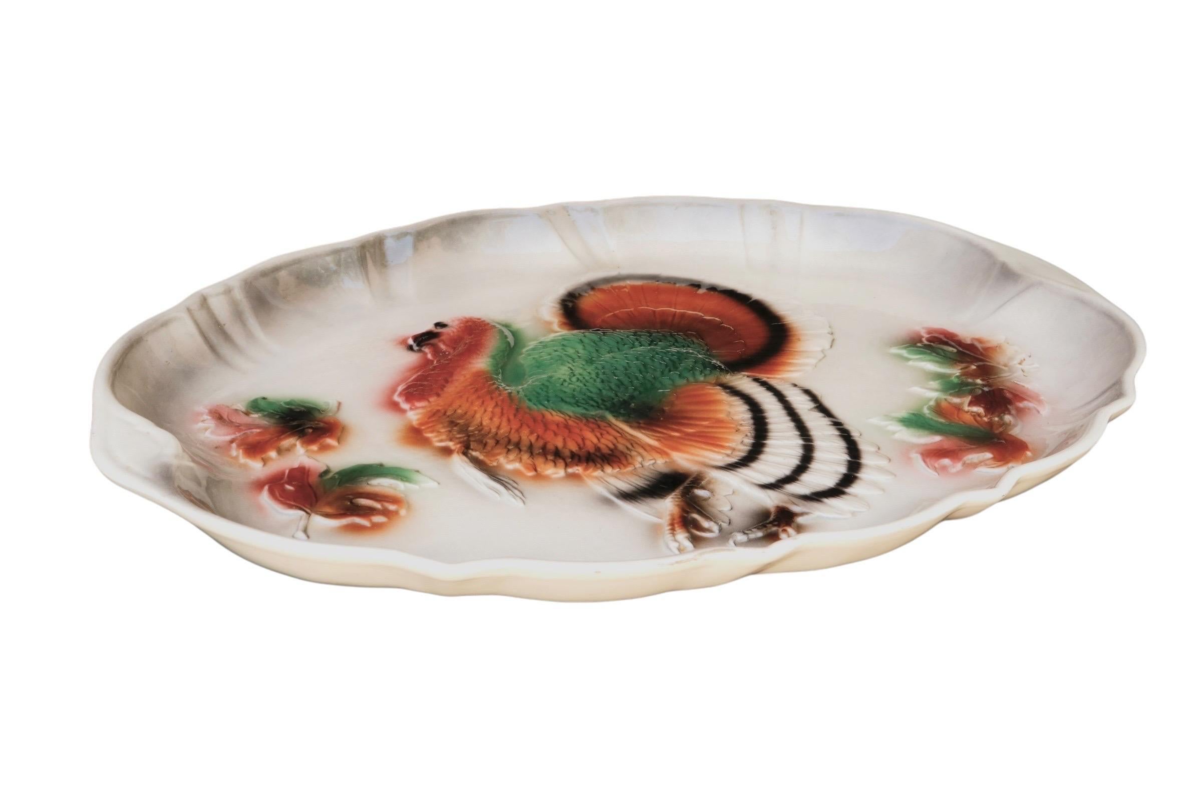 A 1958 ceramic platter made by Lane & Company of Van Nuys, California. The oval platter has an embossed turkey in the center, with fall leaves to each side, and a serpentine raised edge. Airbrushed in brown and green with black details. Marked