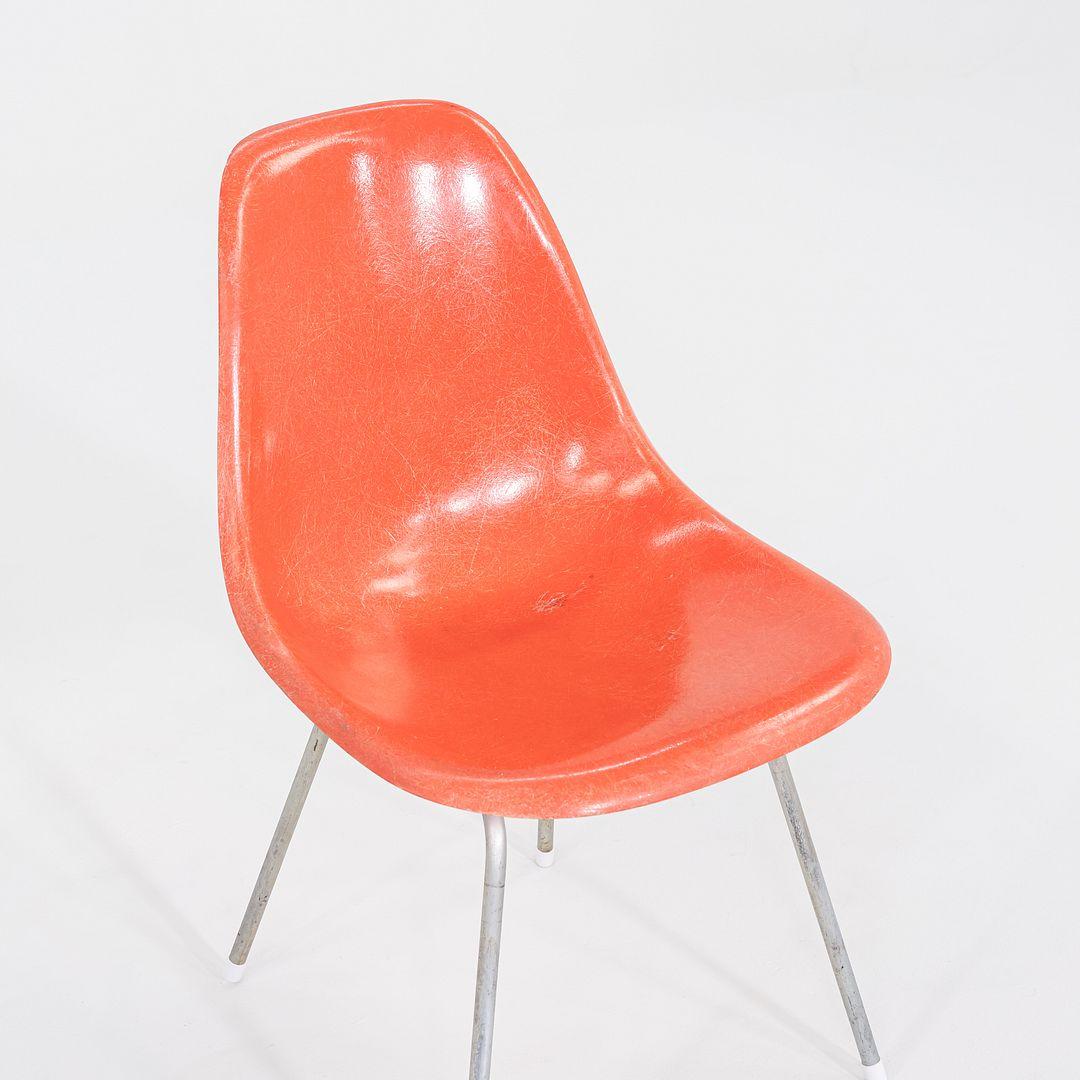 This is a pair of Eames DSX Side Chairs, originally designed by Ray and Charles Eames in the 1950s. These particular examples were produced by Herman Miller in the USA in 1958. The chairs are comprised of fiberglass shells in orange atop a steel