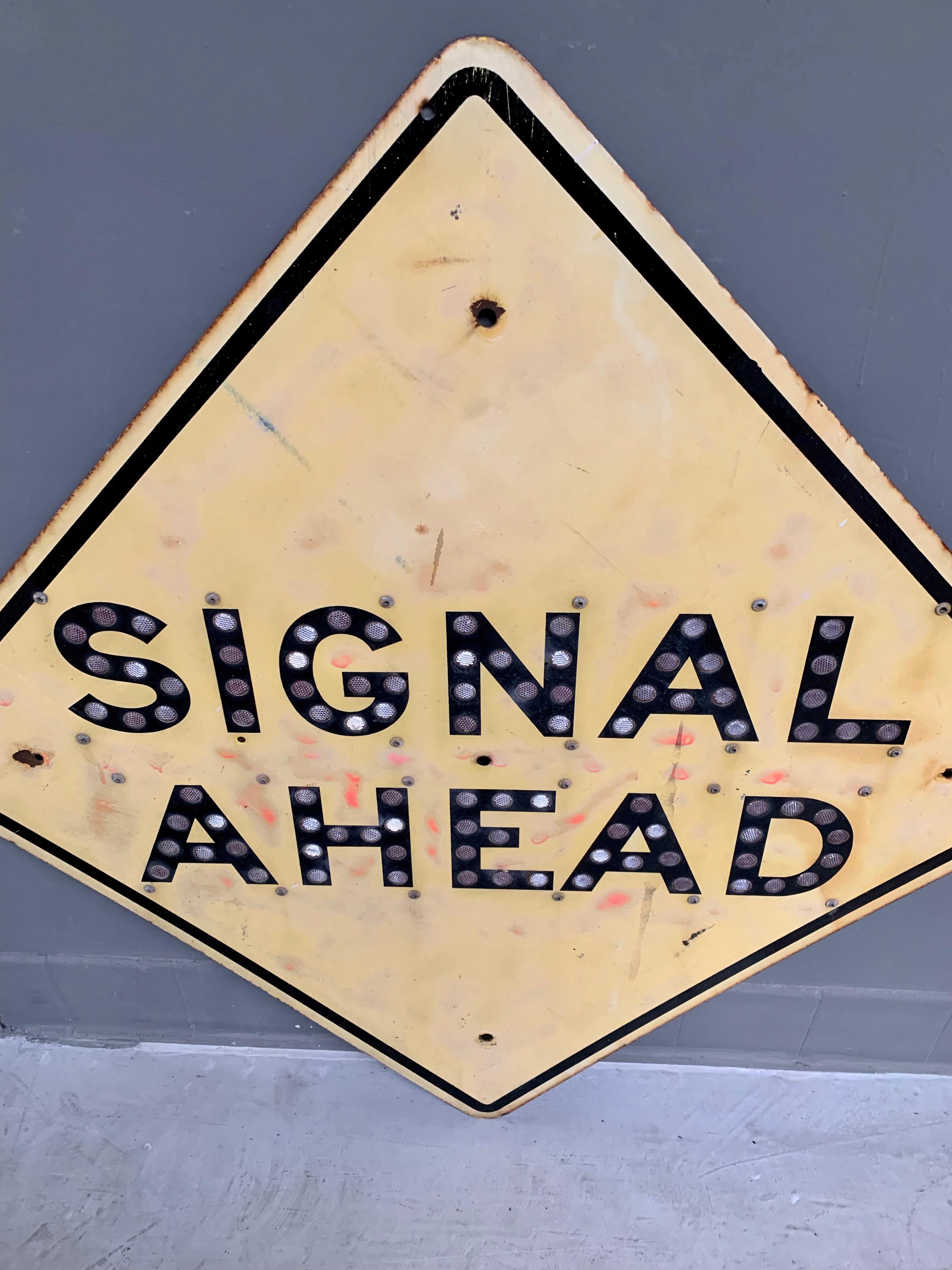 Rare 'Signal Ahead' yellow sign from a California Highway. Letters are made of reflectors. Stamped 'State of California' on the back with the date, 1959. Almost 4 feet wide. Extremely heavy sign made of steel. Great patina. Cool piece of wall art