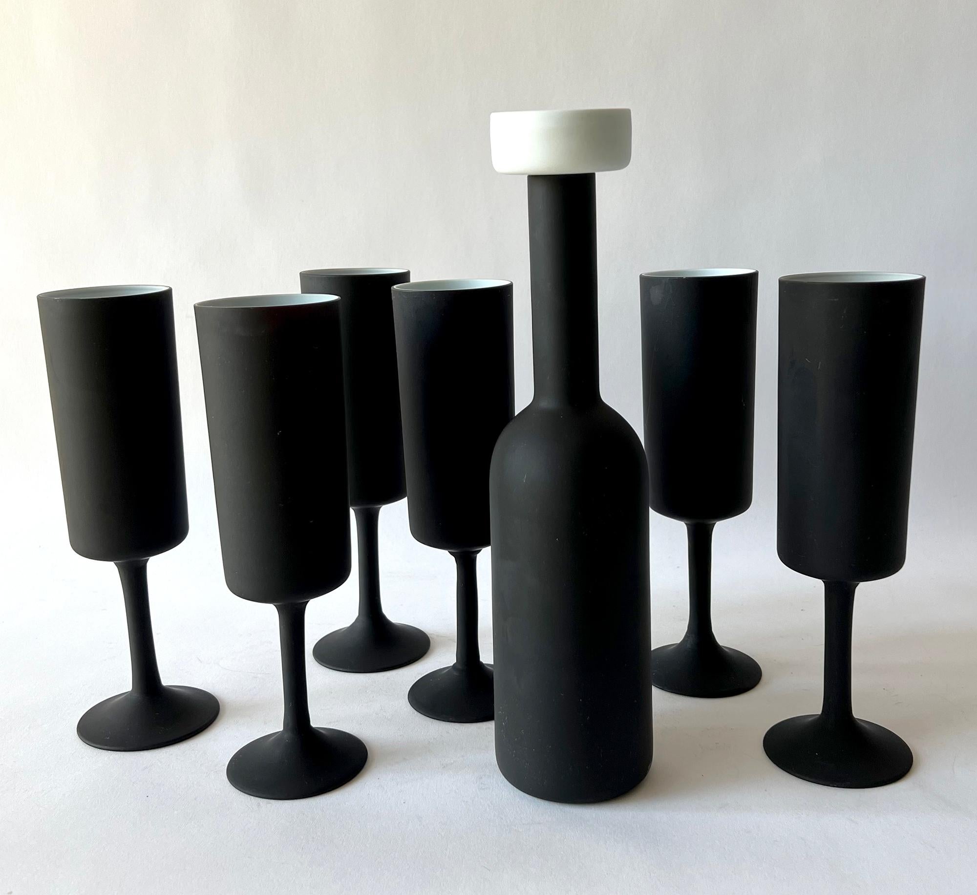 Dramatic, black satin glass with white cased glass interior wine decanter and six glass flute set, created by Carlo Moretti for Cristalleria Nason e Moretti, Murano, Italy. Decanter measures 12