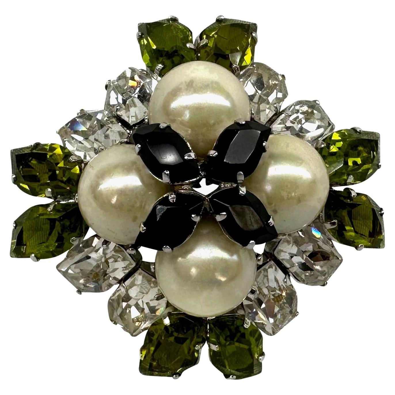 Presenting a stunning faux crystal and pearl Christian Dior brooch. From 1959, this large and opulent brooch features a diamond shape made complete with faux pearls and green, clear, and black crystals. From over 60 years ago, this incredible Dior