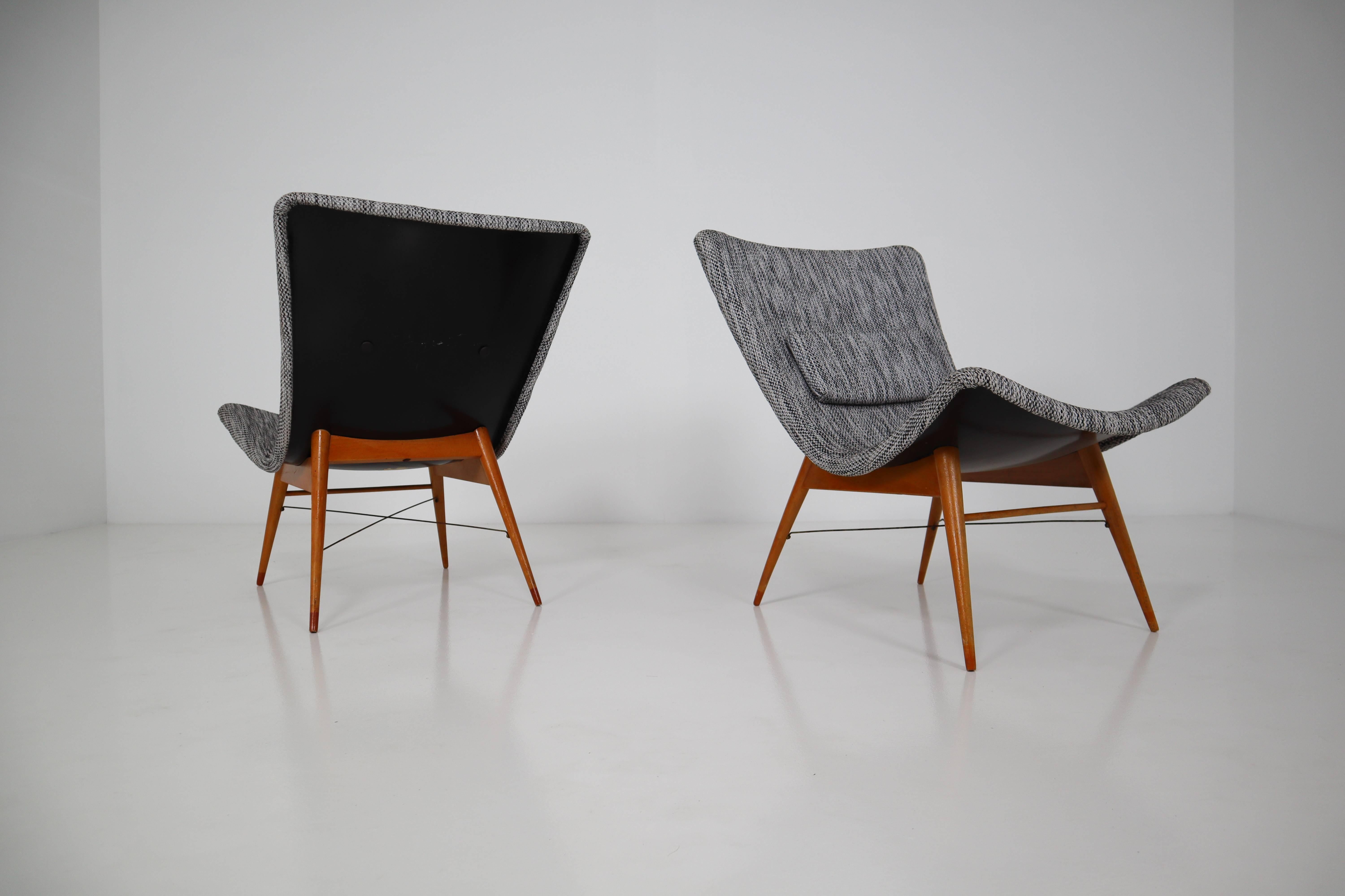 Lounge chairs by Miroslav Navratil, manufactured in former Czechoslovakia by Cesky Nabytek, 1959. Original wooden base, fiberglass shell seating. The backside of the chair is original black color and have a new Reupholstered fabric in grey color.