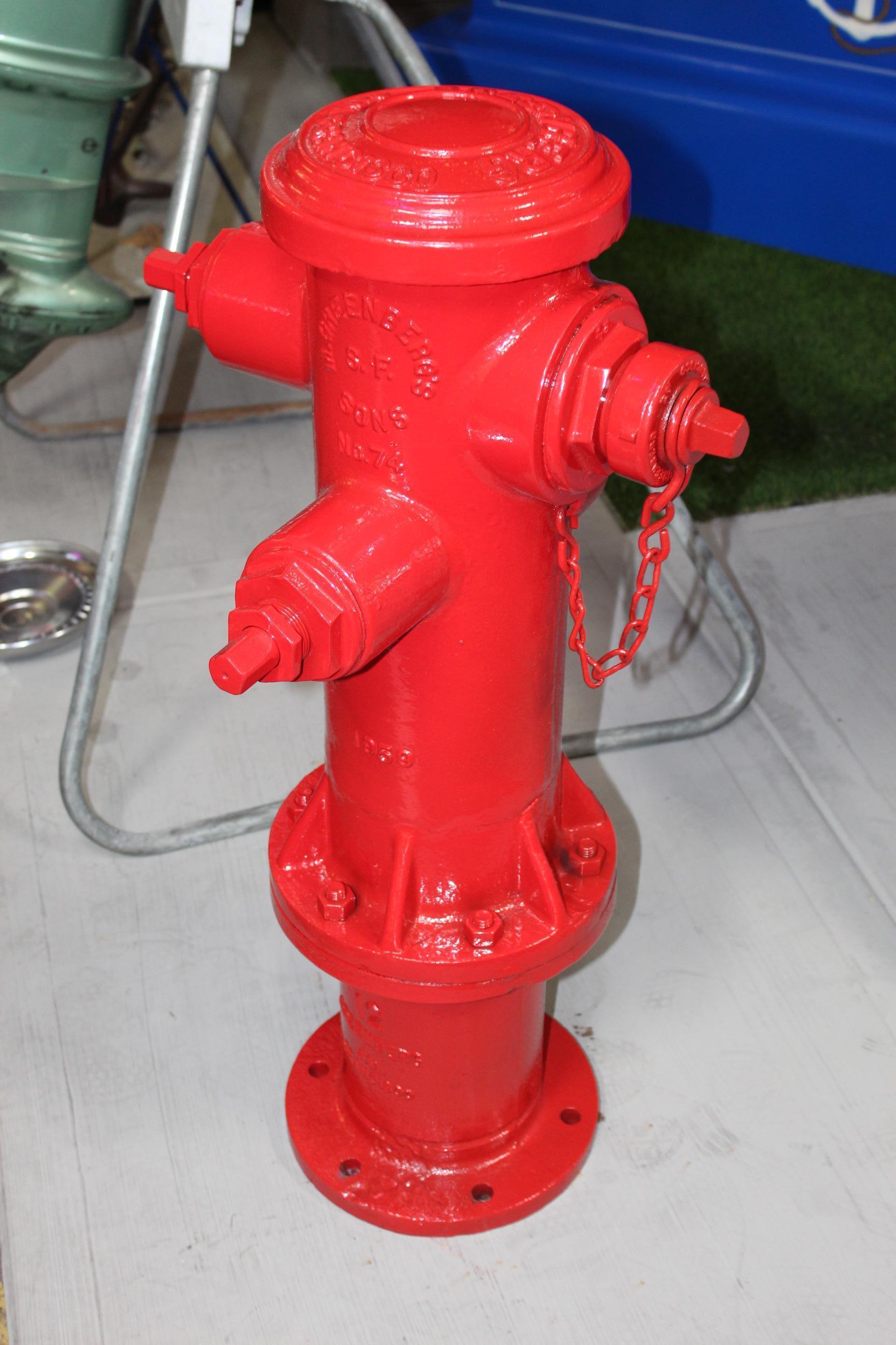 Heavy cast iron fire Hydrant that has been repainted in fire engine red. This is model 74 manufactured in San Francisco.