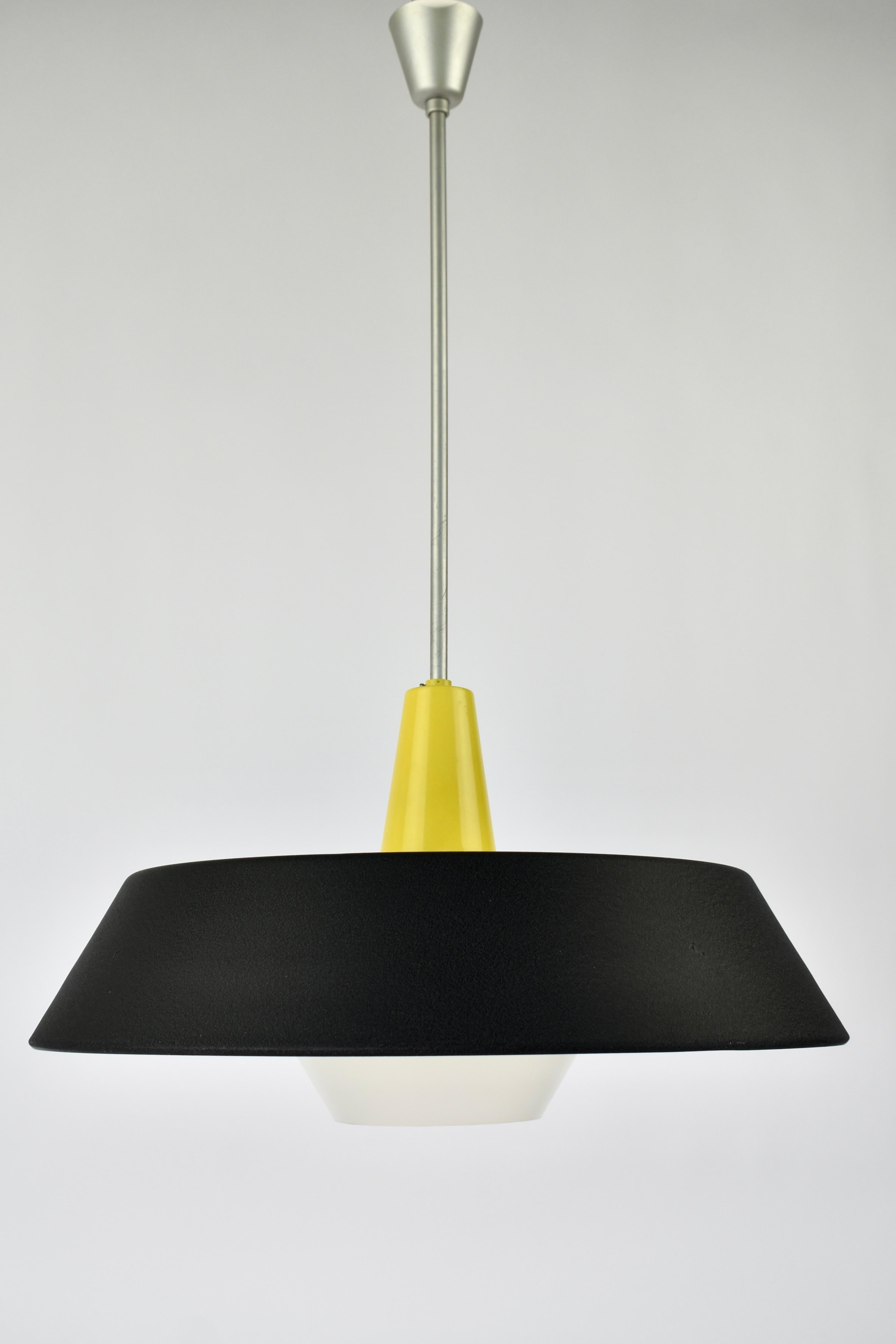 Lampada a sospensione originale Philips modello NB23, progettata nel 1959 da Niek Hiemstra. Esempio di illuminazione industriale olandese, questo pezzo raro fonde la forma funzionale con la bellezza minimalista, rendendolo un elemento di spicco in