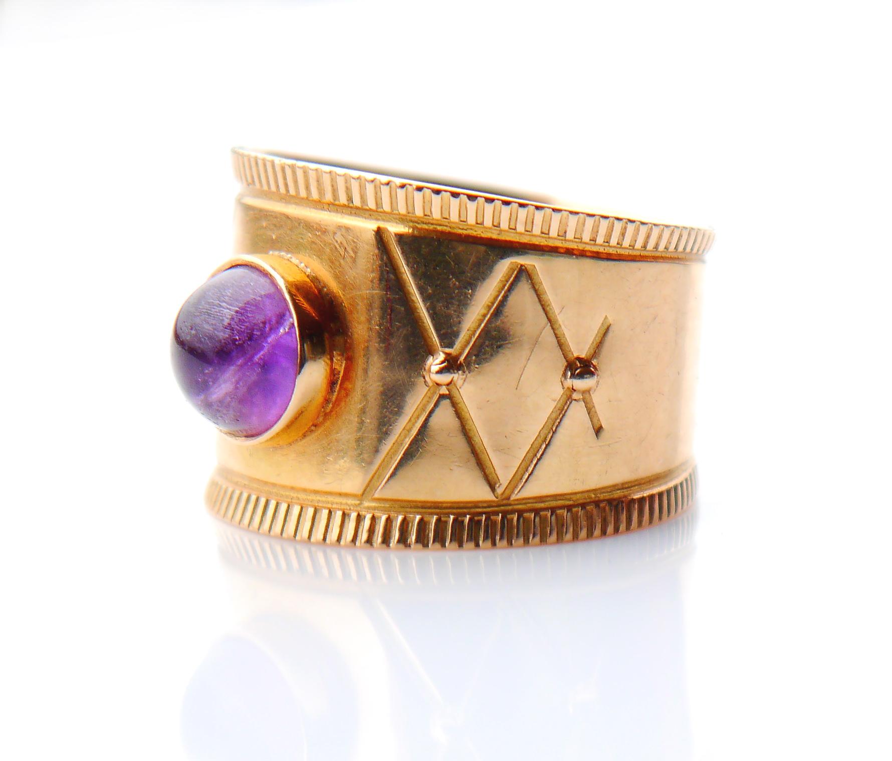 Vintage Ring mit breitem Band mit eingraviertem Ornament, verziert mit einem Cabochon aus natürlichem Amethyst (Ø 6,5 mm x 4 mm tief / ca. 1ct) in Lünette.

Made in Sweden, 18K und Herstellerpunzen. Zeichen des Jahres I9 = hergestellt 1959

Größe Ø
