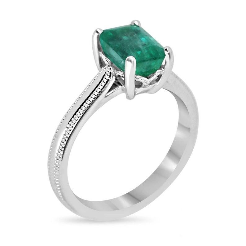 Elegant and captivating, this emerald solitaire ladies' ring is a true statement piece. The centerpiece features a stunning emerald cut emerald from Zambia, exuding a lush green hue that mesmerizes the eyes. Set vertically in a four-prong mount, the