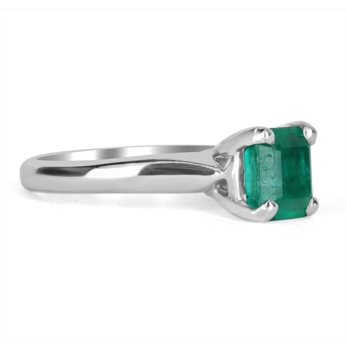 Se muestra este precioso anillo solitario de esmeralda colombiana. Una esmeralda colombiana talla Asscher de 1,95 quilates acapara toda la atención, con su precioso color verde medio oscuro y muy buen brillo. Está delicadamente engastado en un