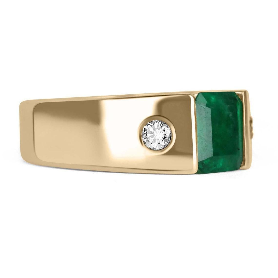 Displayed is a classic emerald & diamond three stone men's ring in 14K yellow gold. This solitaire ring carries a full 1.90-carat emerald in a secure tension setting. Fully faceted, this gemstone showcases excellent shine and brilliance. The emerald