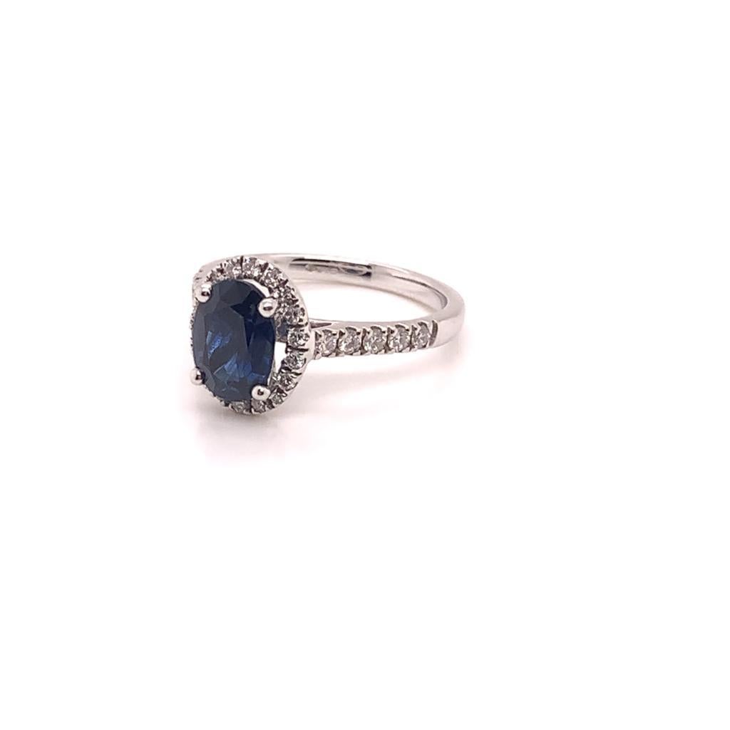 At the centre of this Stunning ring is a Gorgeous Oval Blue Sapphire weighing approximately 1.96 Carats and it is surrounded by Round Brilliant Diamonds which weigh approximately 0.35 Carats. Set in 18k White Gold, this ring turns heads with its