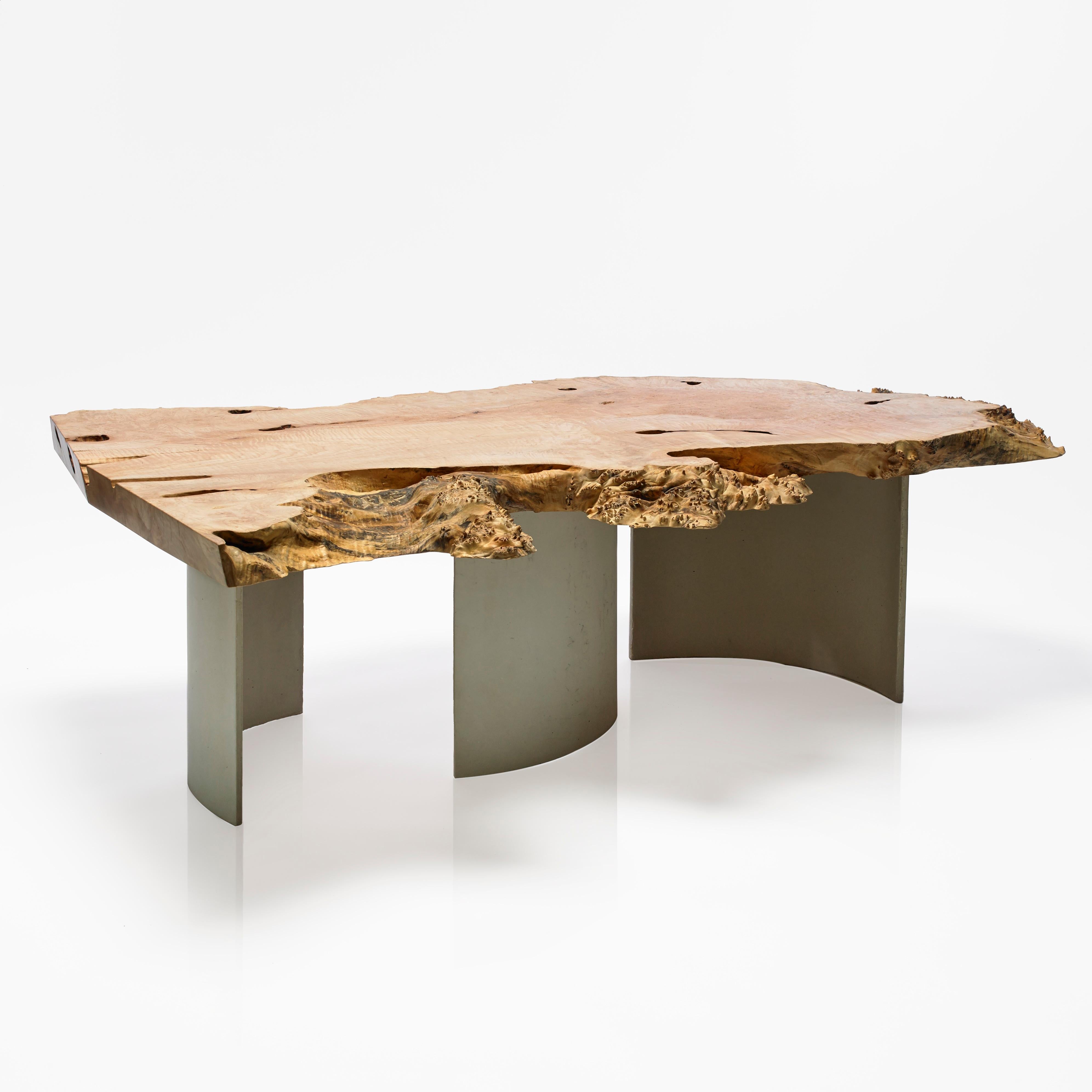Une table basse moderne, sculpturale et naturelle qui vieillira avec élégance. Une pièce d'érable spalted posée sur trois pieds en béton incurvés, espacés pour suivre les courbes naturelles du plateau et du grain, en utilisant un béton haute