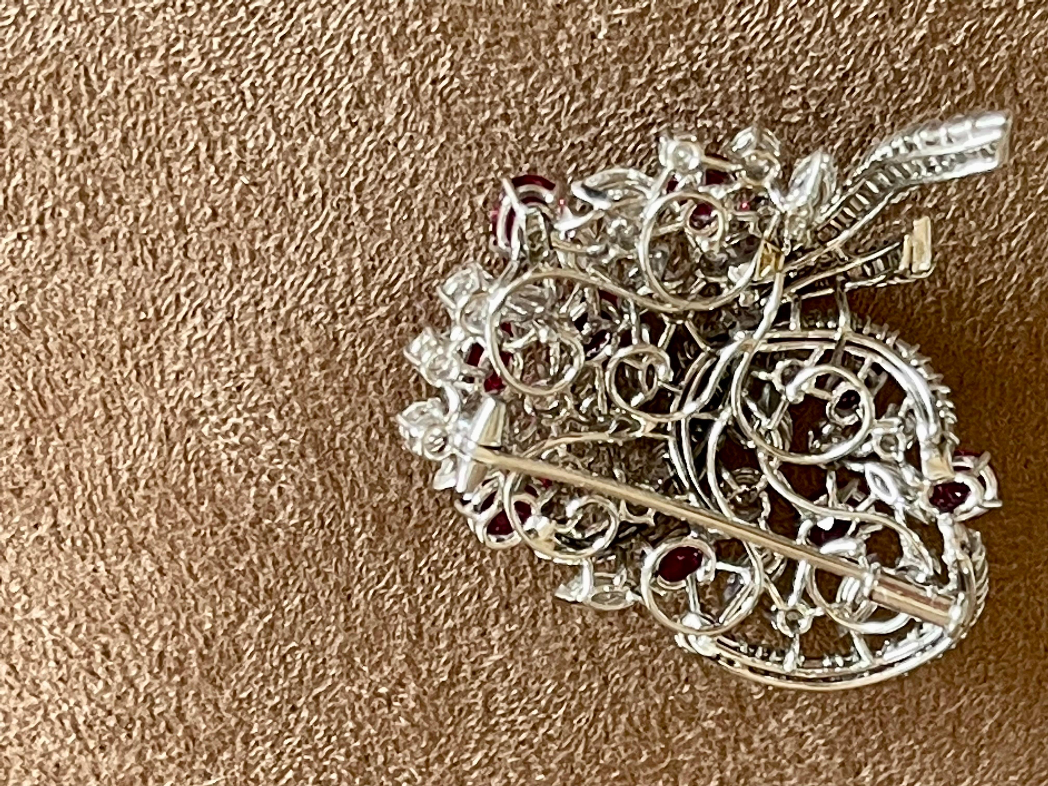 A stunning, fine and impressive 18 K white Gold cluster brooch from the 1960 set with 10 Rubies weighing approximately 2.50 ct and Diamonds (Marquise cut, baguette cut and brilliant cut)  weighing approximately 6.80 ct, F color, vvs clarity.
Images