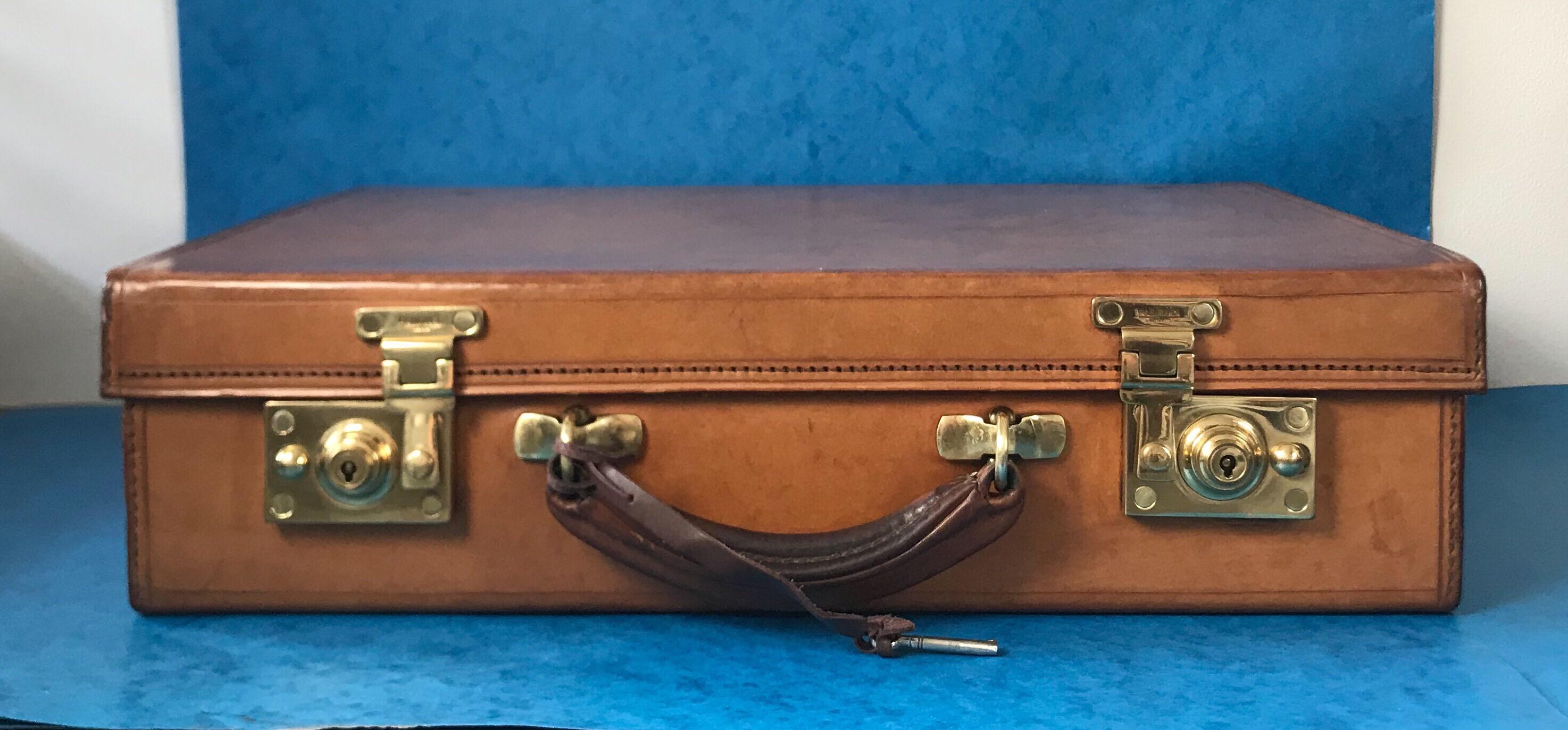 A 1960-1970 hide leather attaché case by “W & H Gidden” the leather is in superb condition, it has good quality gilt and brass fittings, it has a working lock and key, a stationary compartment to the back and a royal stamp to the back of the
