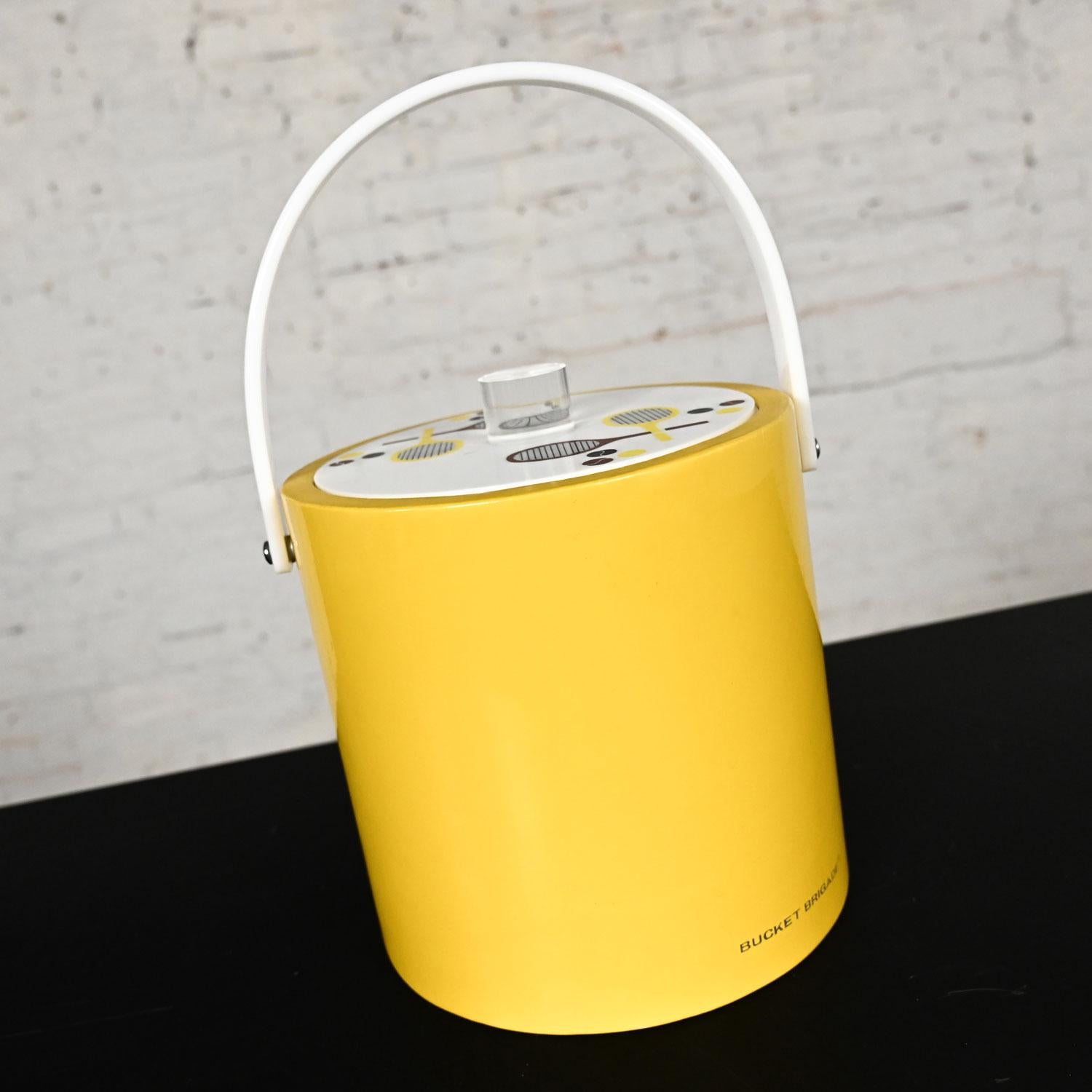 Handsome vintage MCM or Mid-Century Modern Morgan & Company Bucket Brigade yellow faux patent leather ice bucket with tennis designs on a plexiglass lid, lucite knob, white lucite handle, and plastic inside lining. Beautiful condition, keeping in