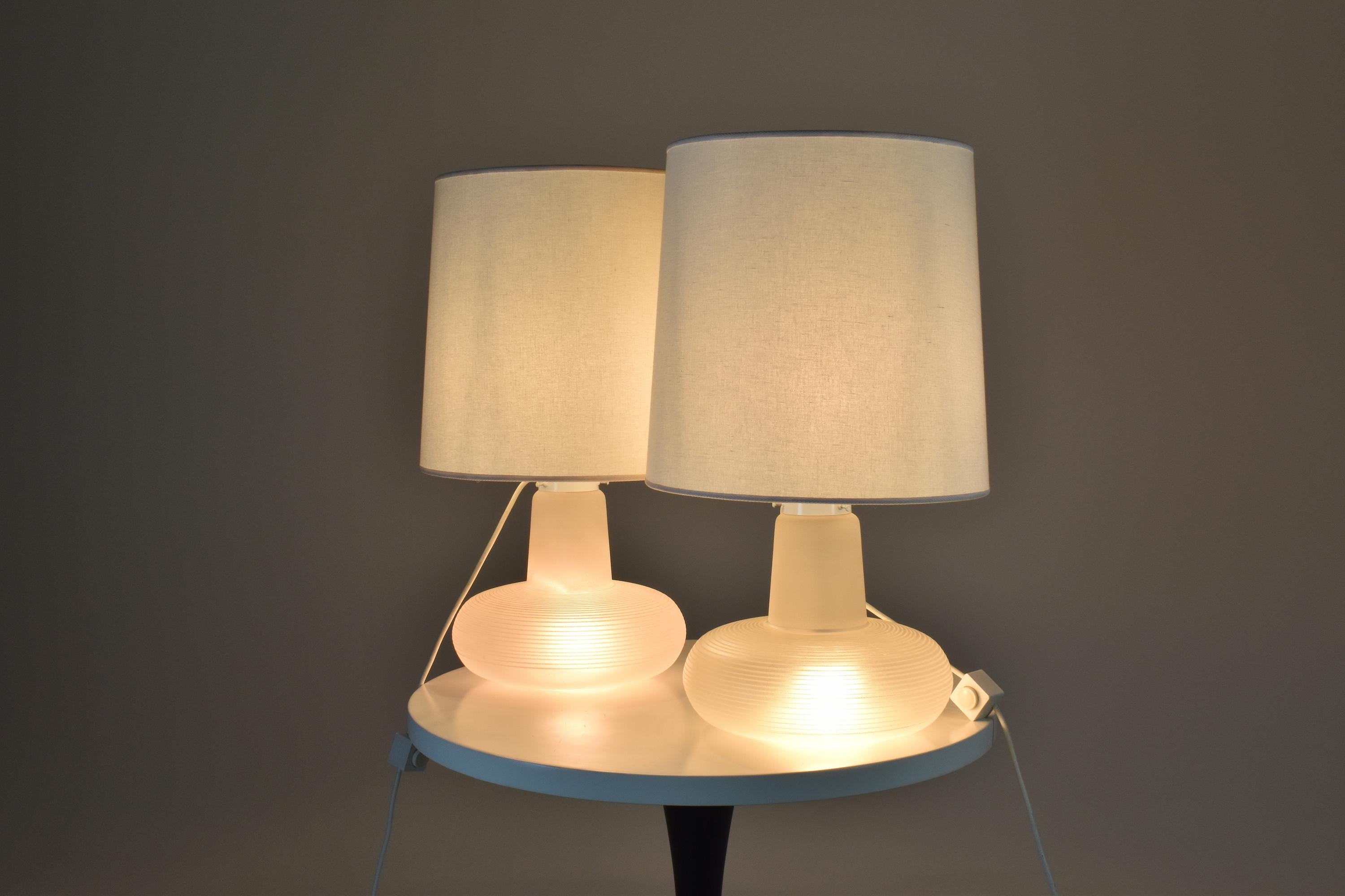 Fantastic set of two curvacious vintage 20th-century table lights attributed to Italian Murano glass expert Carlos Nason for Mazzega around 1960-1970. The beautiful transparent glass is sandblasted at the top and designed with horizontal lines
