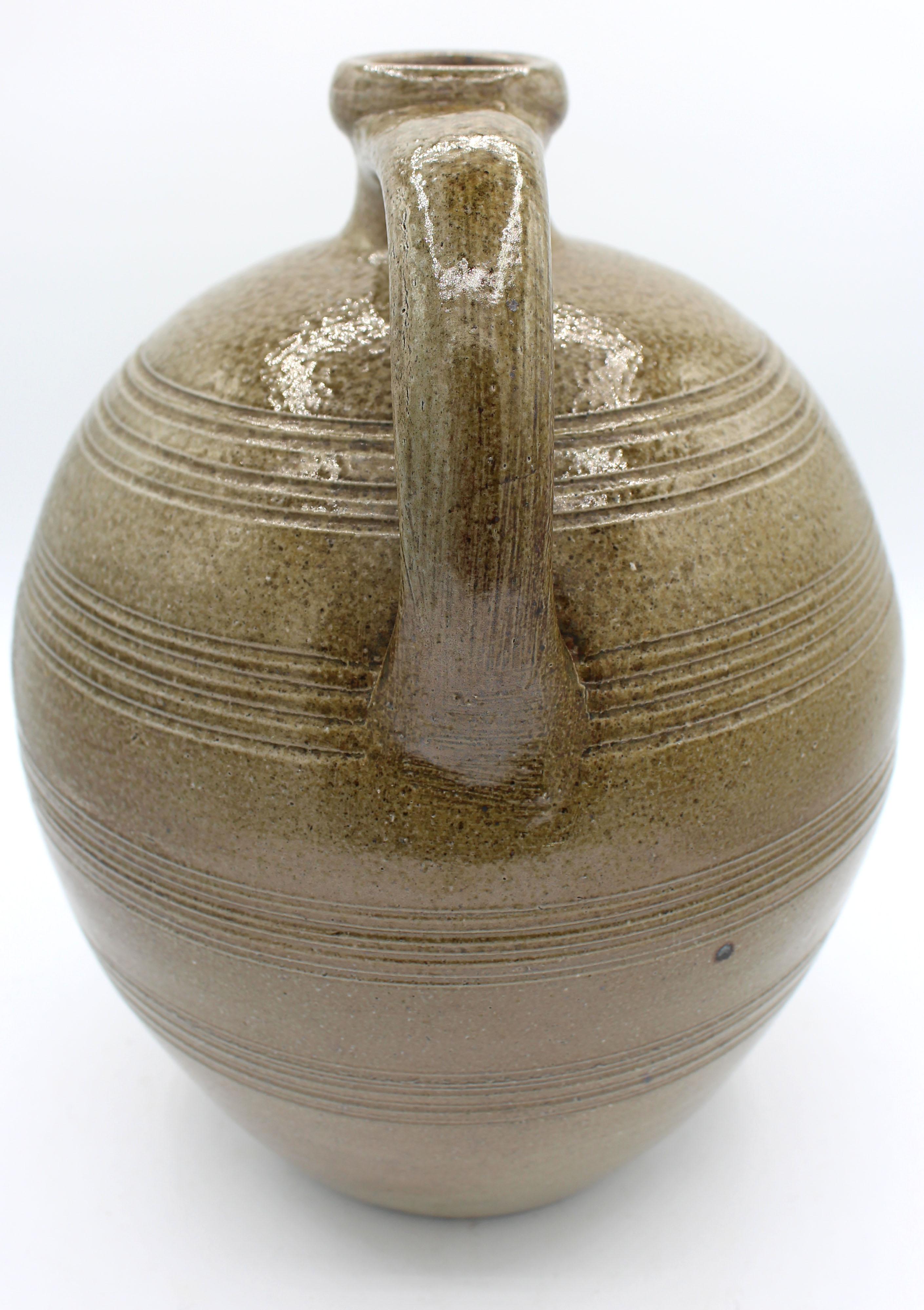 1960-1972 salt glazed pottery jug by Ben Owen I, Seagrove, NC. Large & elegantly formed with ring incised decoration; marked 