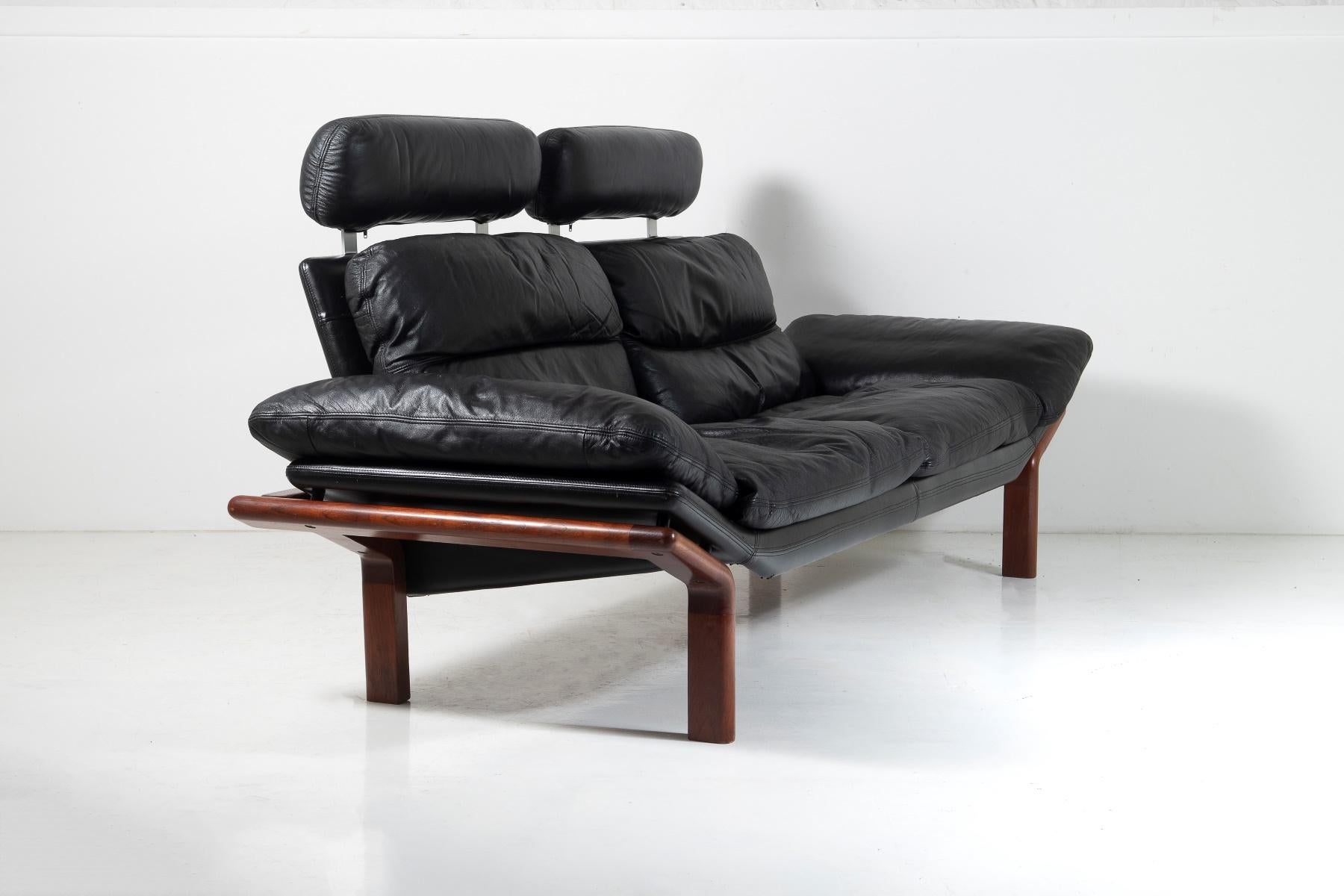 A high-quality Mid Century designer sofa by Danish maker Komfort, a superb piece in excellent original condition.  A piece with great form and finish, with a dark teak /ask wrap around frame in this unusual design, against a black leather base and