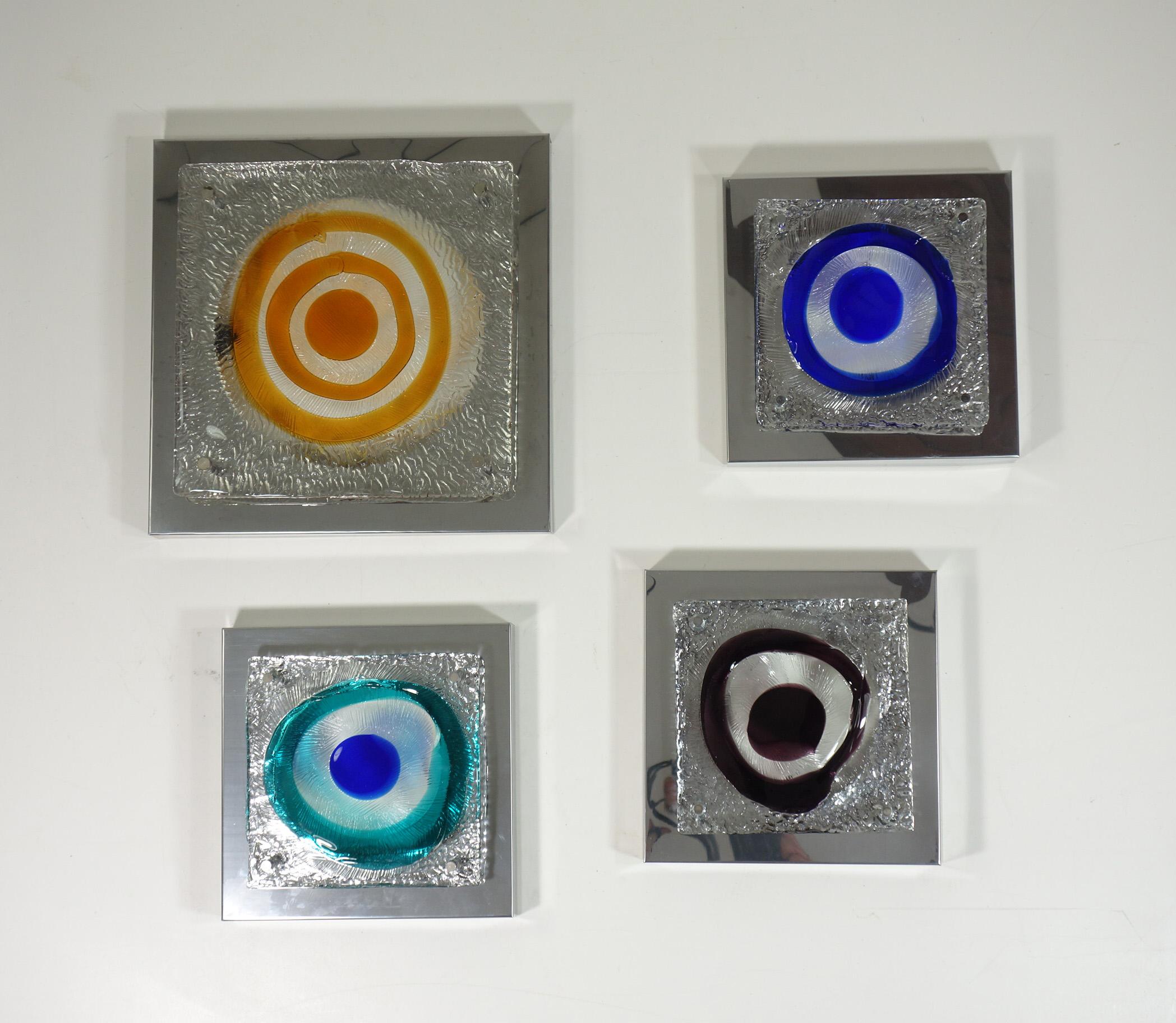 Juego de 4 lámparas de pared
Angelo Brotto 
Esperia
Italia, 1960

Estructura de acero pulido y pantalla de cristal de Murano coloreado

3 lámparas pequeñas h 7 x 25,5 x 25,5 cm_ 2 bombillas (E14)
1 lámpara naranja grande  h 7 x 35,5 x 35,5 cm _ 4