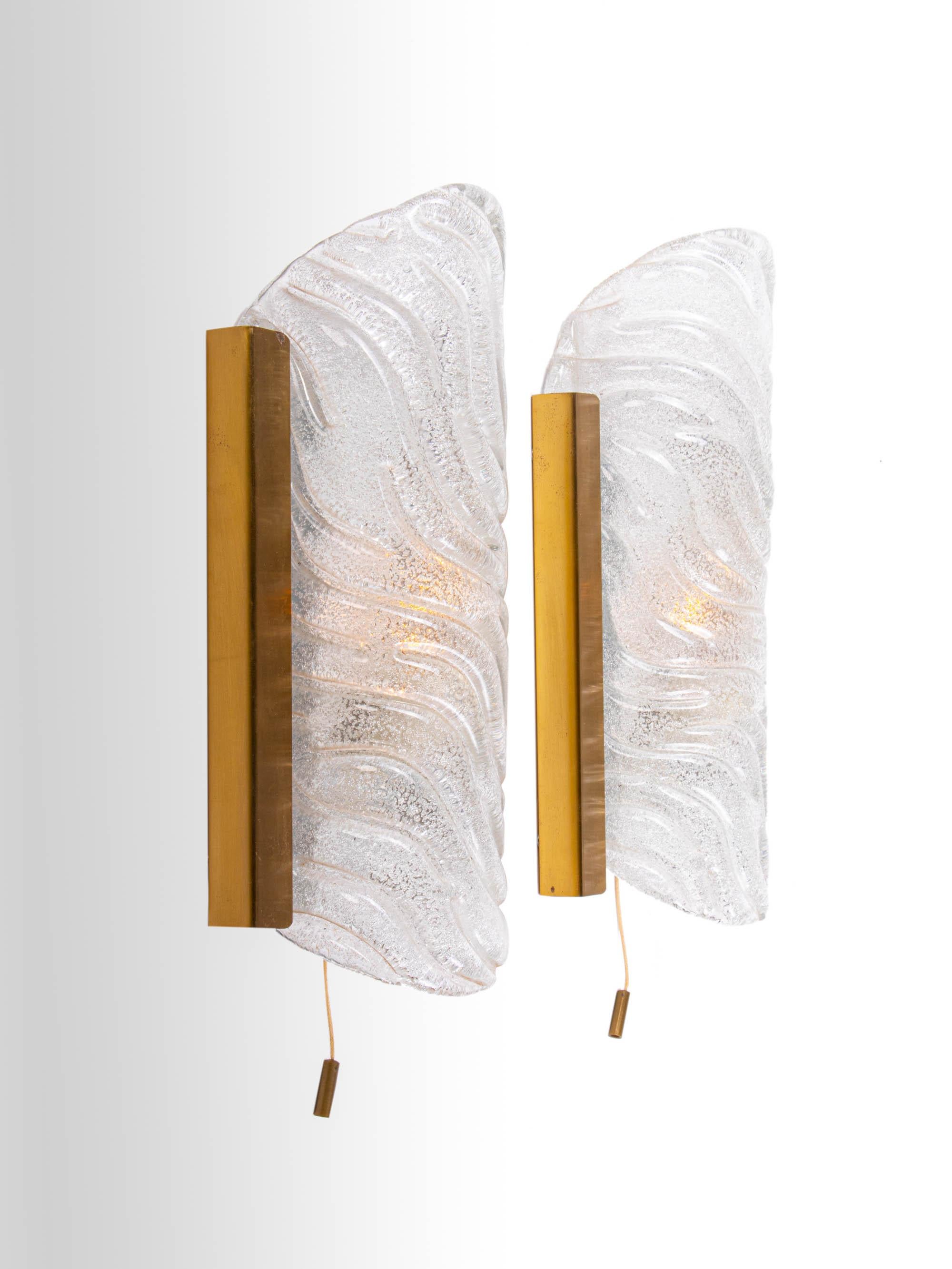 Elegantes Paar moderner Wandleuchter, entworfen von J.T. Kalmar. Die dicken Murano-Glaselemente ähneln Eiszapfen, die auf einem goldenen Messingrahmen befestigt sind. Jede Lampe gibt ausreichend indirektes warmes Licht ab. Mit dieser Leuchte setzen