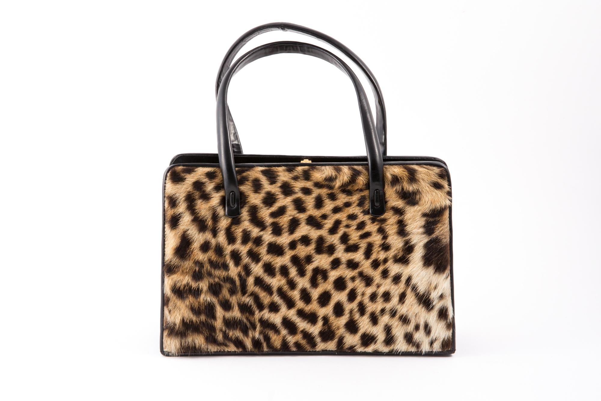 1960 black leather and printed leopard handbag bag  featuring a top gold-tone lock closure, two tops handles, both sides with printed leopard, inside camel compartments.
Length: 9.8in. (25cm)
Height: 6.2in. (16 cm)
Width:2.7in (7cm)
Handles Length: