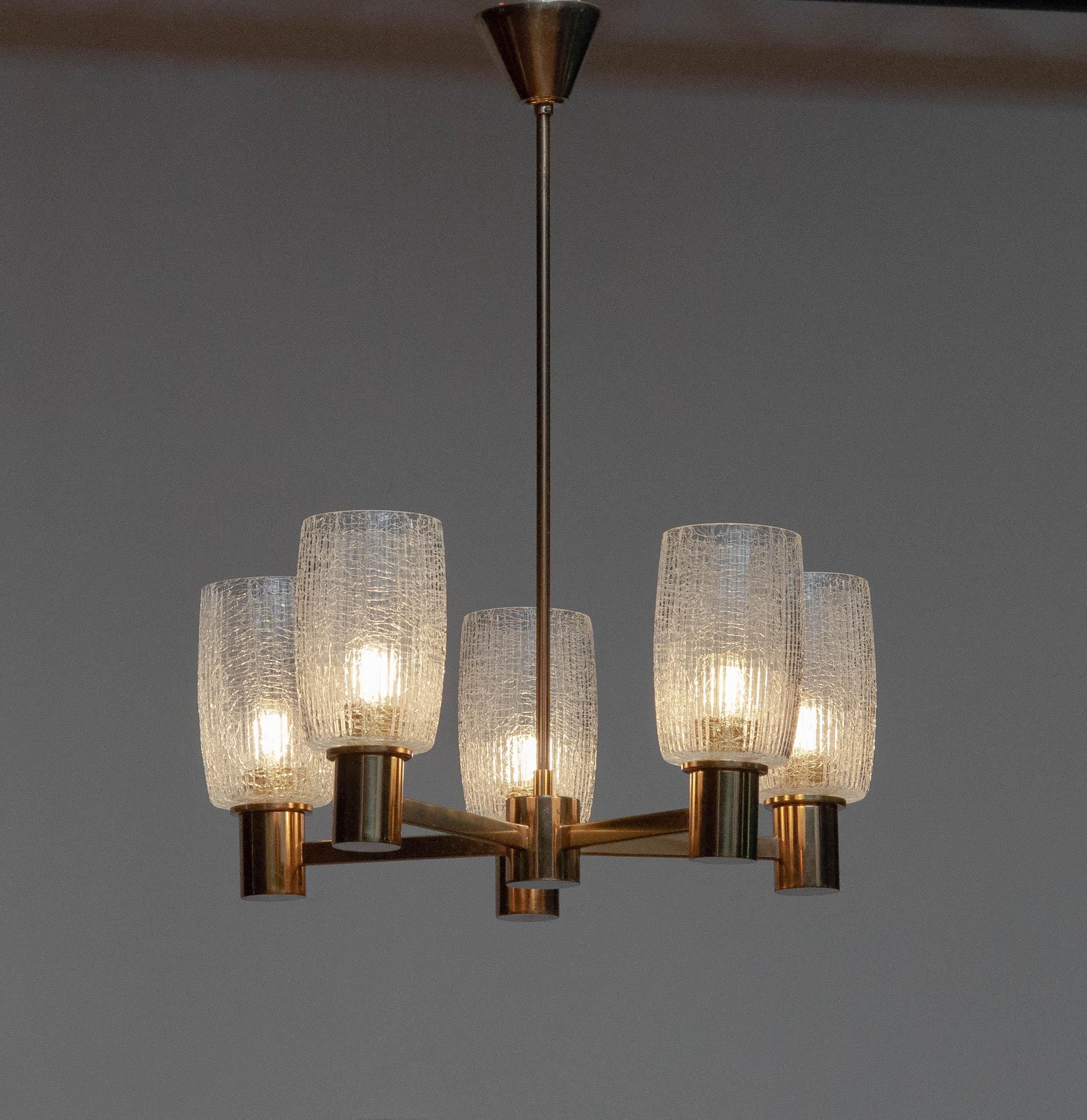 Beautiful brass chandelier manufactured in Germany by Doria in the 1960s.
The five large  ( 15 cm / 5.91 inches height and 10 cm / 3,94 inches in ø ) vases in clear crackled glass gives the chandelier a great sparkling effect and therefor 