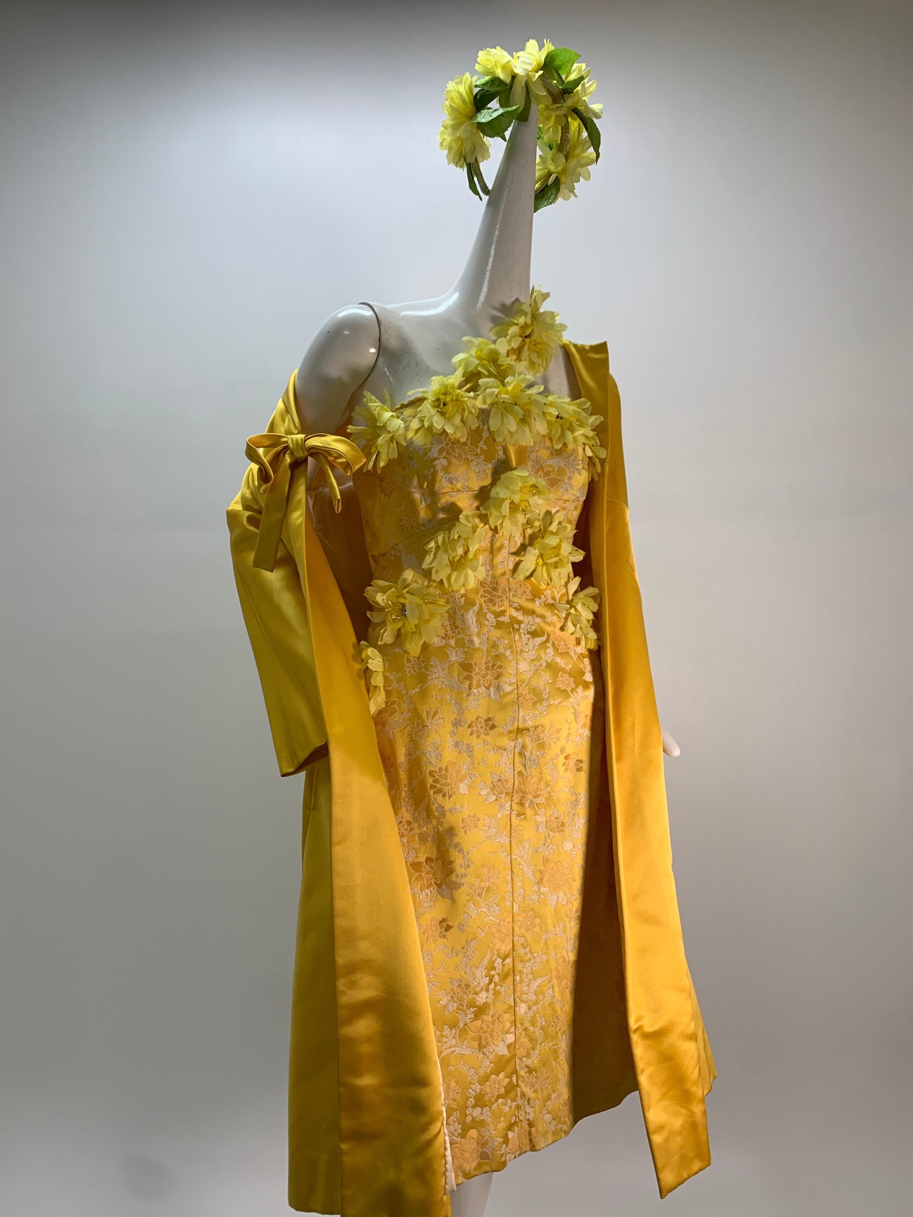 1960s Canary yellow silk brocade cocktail dress and opera coat ensemble: Floral brocade dress features applied silk flowers at bodice and neckline. Jacket is beautifully tailored and seamed with a bow at front closure. Fully lined, with back zip