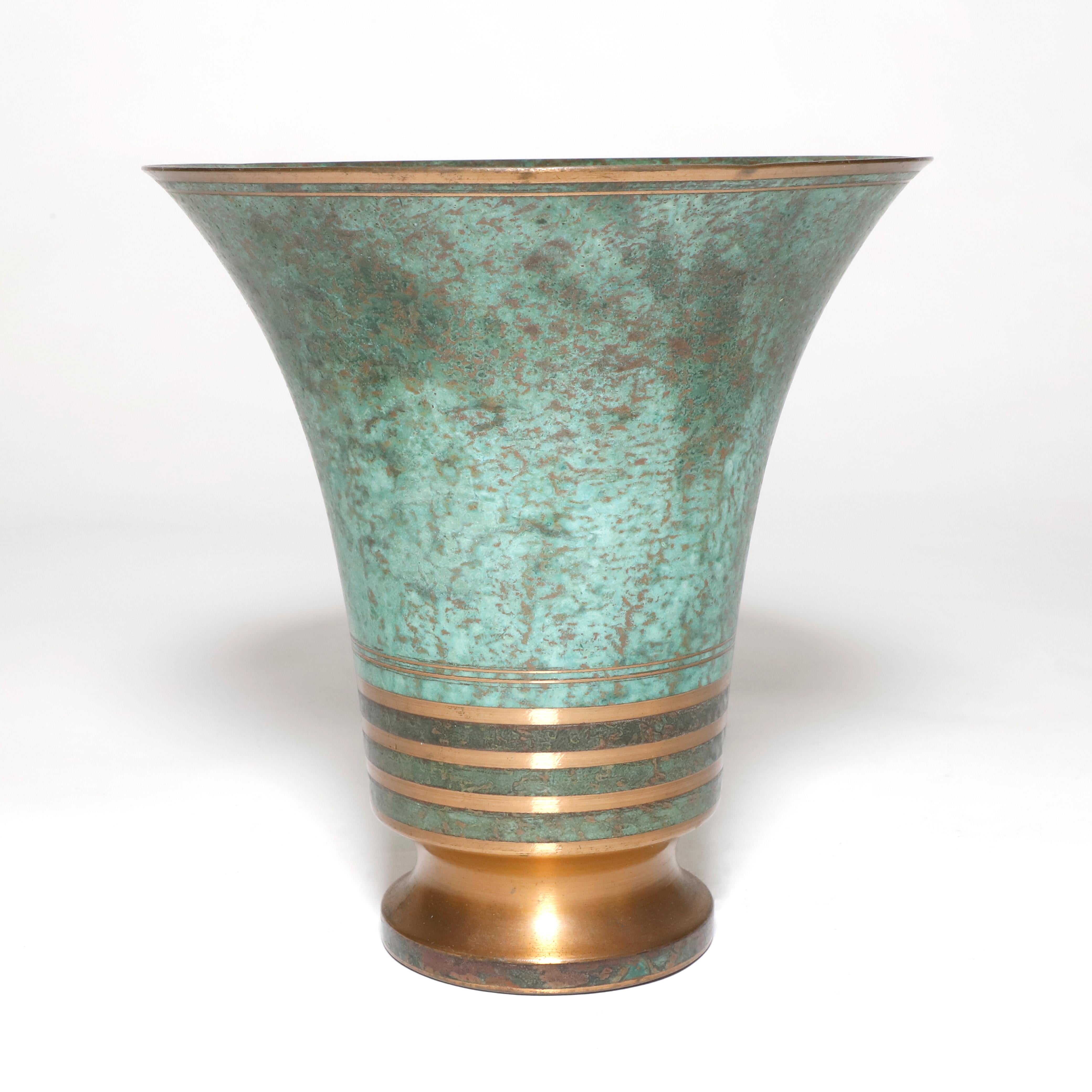 1960 patinated bronze base by the famous designer Carl Sorensen. This Art Deco piece has shinny bronze lines evenly spaced in the rim and bottom of the vase that give great contrast with the natural green patina. Stamped and signed at the