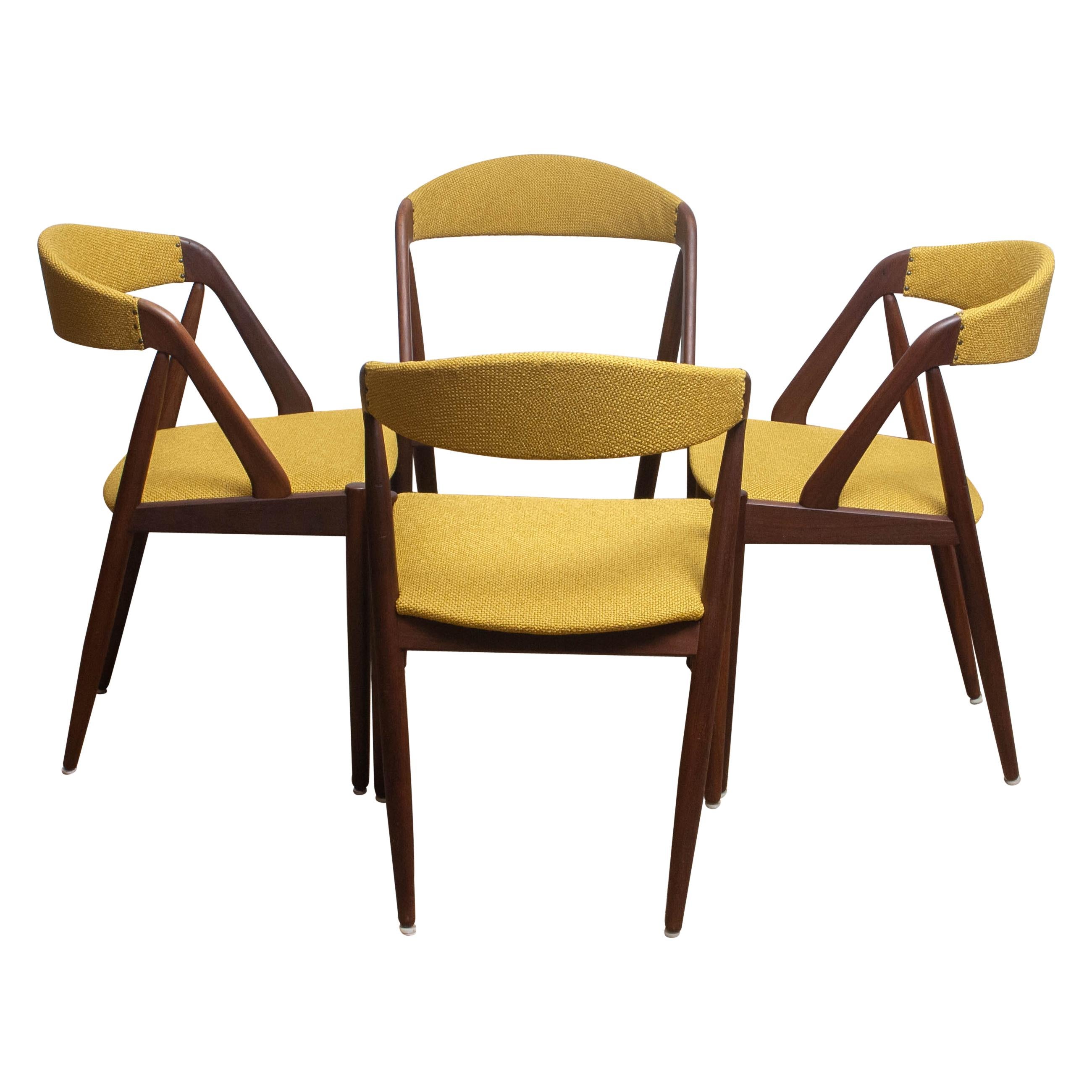 A beautiful set of four dining chairs by Kai Kristiansen for Shou-Andersen Møbelfabrik. The chairs are made of walnut frames with new ochre / gold color upholstery. They are in a wonderful condition. Period: 1960s.