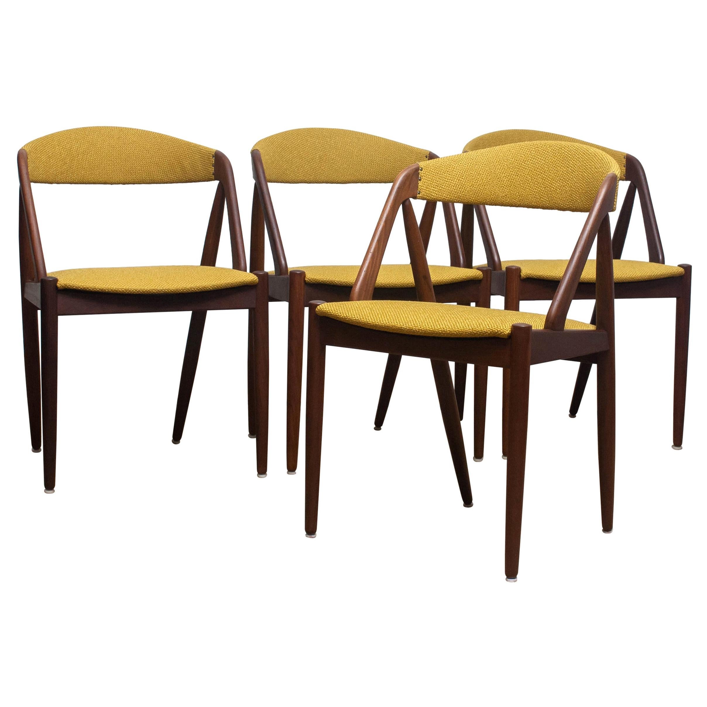 A beautiful set of four dining chairs by Kai Kristiansen for Shou-Andersen Møbelfabrik. The chairs are made of walnut frames with new ochre / gold color upholstery. They are in a wonderful condition. Period: 1960s.