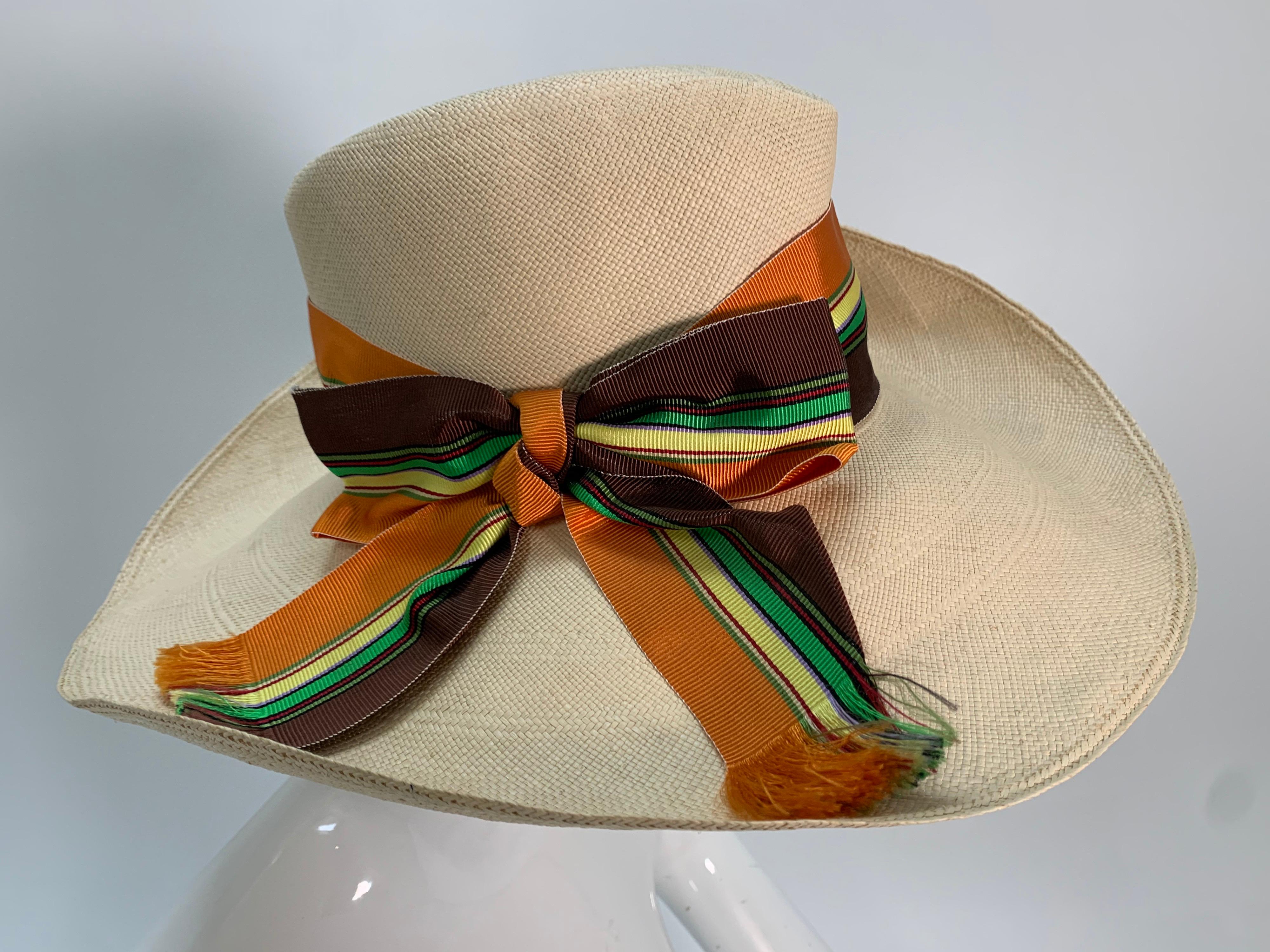 A stylish 1960s Frank Olive natural straw wide-brimmed sun hat with green and brown striped grosgrain ribbon band with a graceful curve to the brim. Squared, tall crown and pink inner grosgrain band. Fits up to medium. 