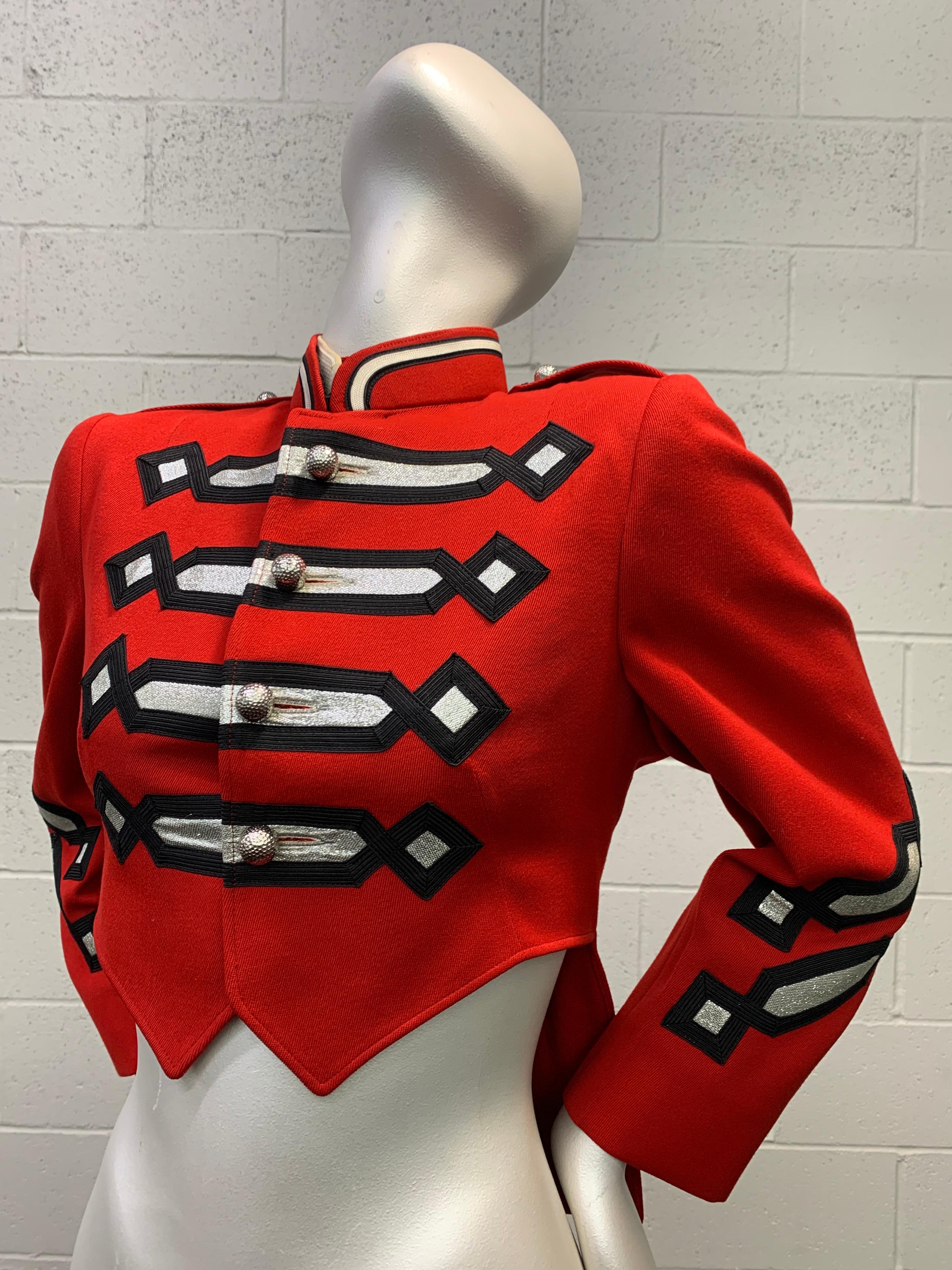 A fabulously graphic 1960s Fruhauf cardinal red wool band uniform jacket with cutaway-front short points and tails in back. Striking military styling and embroidery work in black and silver metallic on front and back. Silver buttons and epaulets at