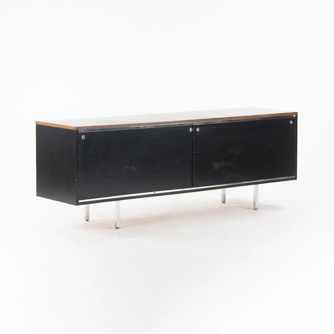 Listed for sale is a gorgeous 8000 series Executive Office Group sliding-door cabinet / credenza, designed by George Nelson and produced by Herman Miller. This example dates to circa 1960 and is finished with a walnut top and ebonized wood casing.