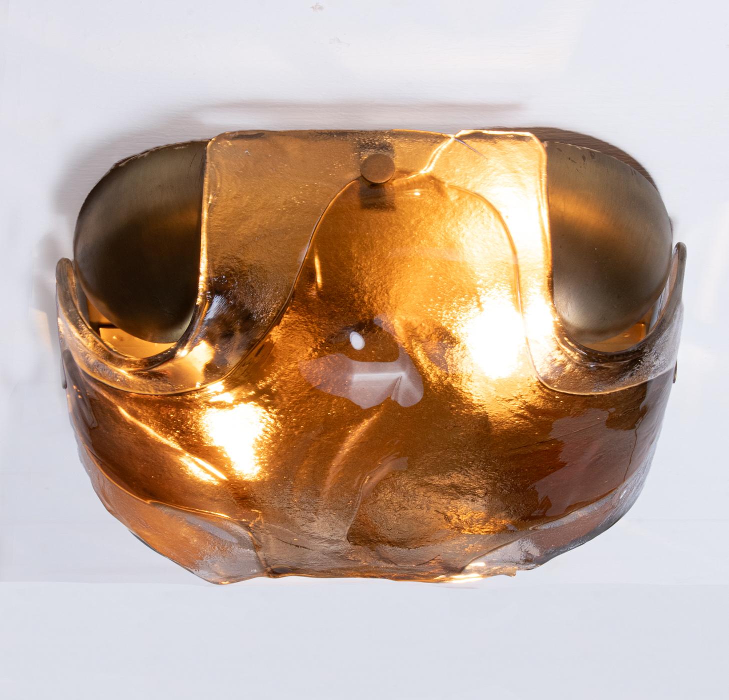 Elegante Wandleuchte aus dickem Murano-Glas auf einem Messingrahmen. Schmuckstück aus der Zeit. Mit dieser Leuchte setzen Sie ein klares Statement in Ihrer Raumgestaltung. Auch im unbeleuchteten Zustand ein echter Blickfang. Hergestellt von Kaiser