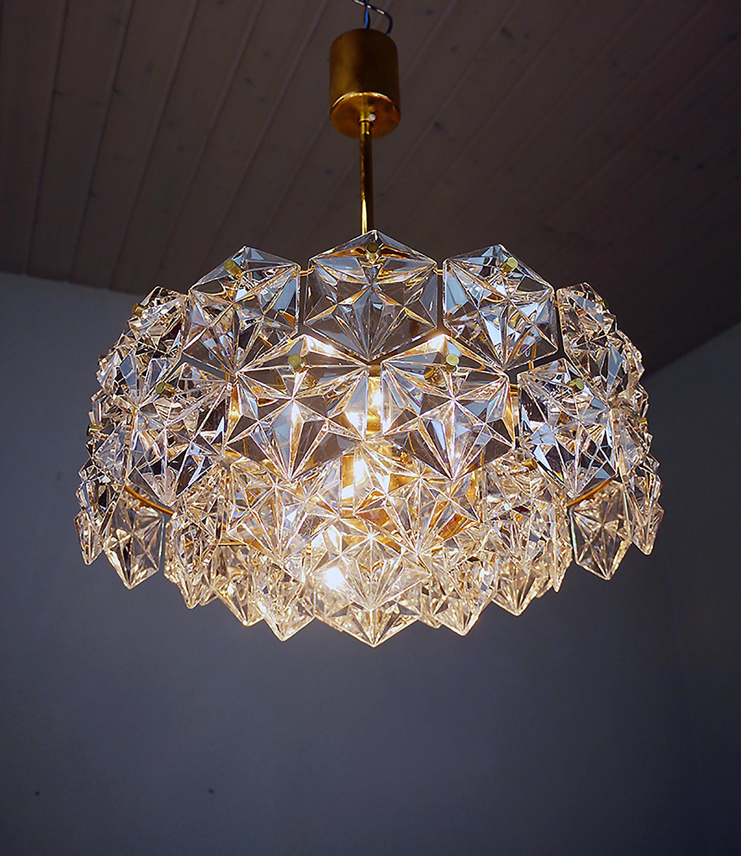 Elegant starburst chandelier with 46 sculptural faceted crystals on a round gold-plated brass frame. Has 7 sockets. In very good condition. Chandelier illuminates beautifully and offers a lot of light. Gem from the time. With this light you make a