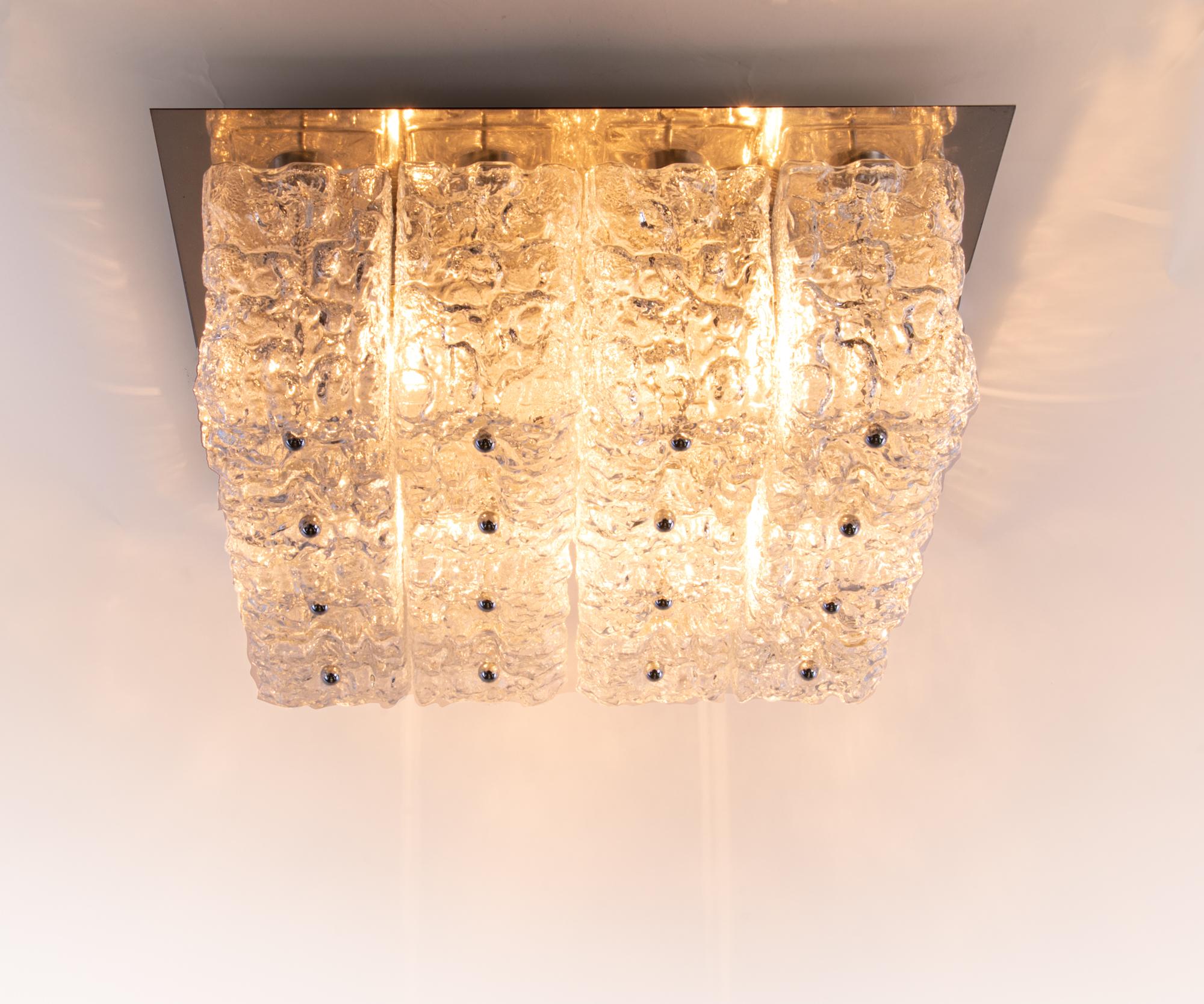 Elegant large cubist flush mount ceiling lamp with sixteen large glass blocks with a textured structure fixed on a golden brass frame with chrome finals by the Finnish designer Helena Tynell attributed. Gem from the time. Heavy design. Manufactured